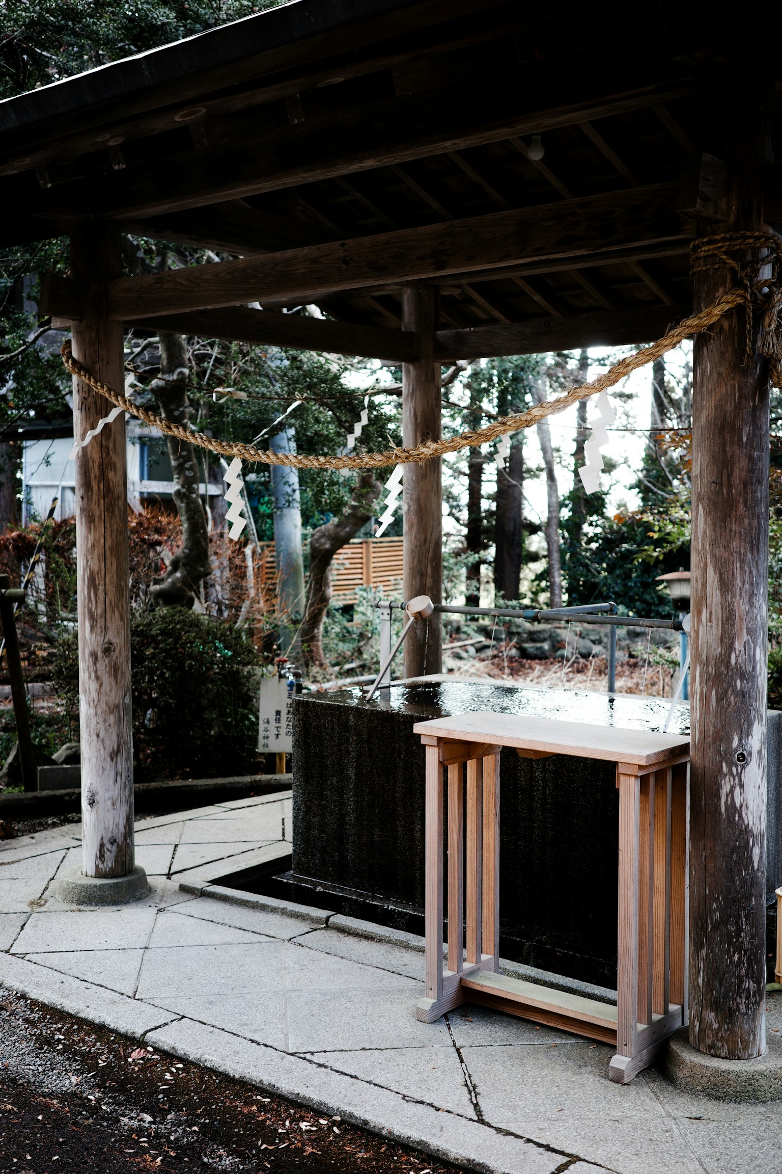 Scena di un santuario con un bacino di purificazione e un altare sotto un tetto di legno