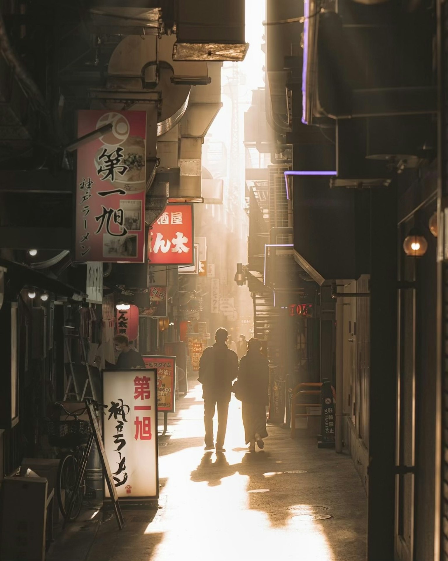 Couple marchant dans une ruelle étroite illuminée par des enseignes au néon à Tokyo
