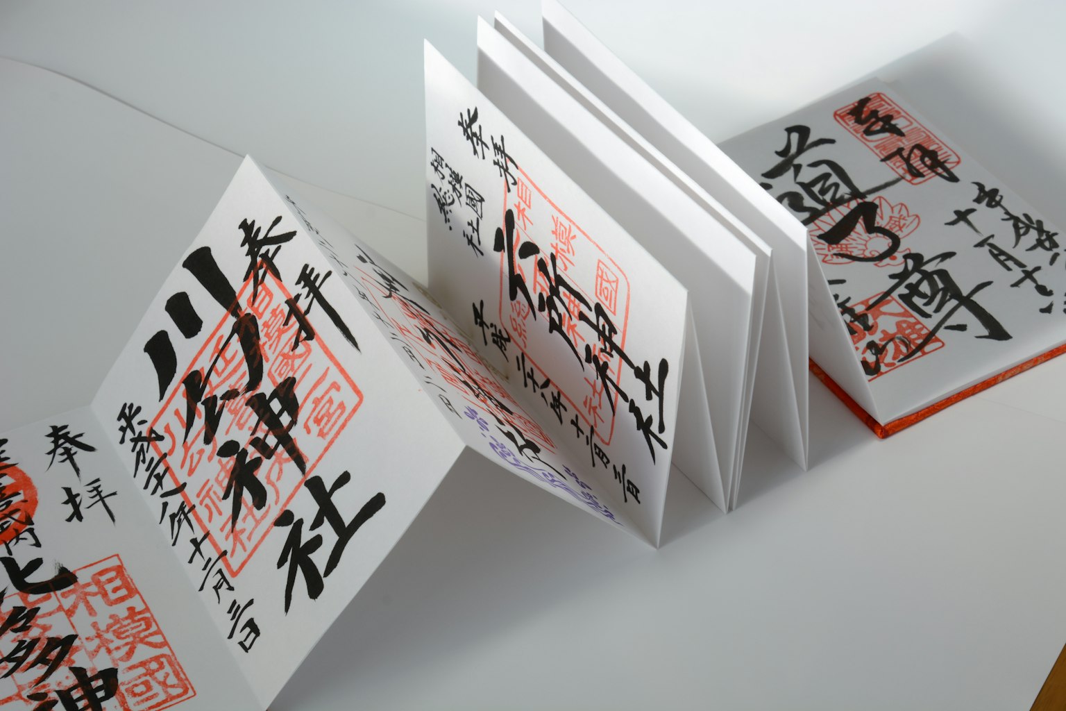 Folded booklet with red and black calligraphy on a white background