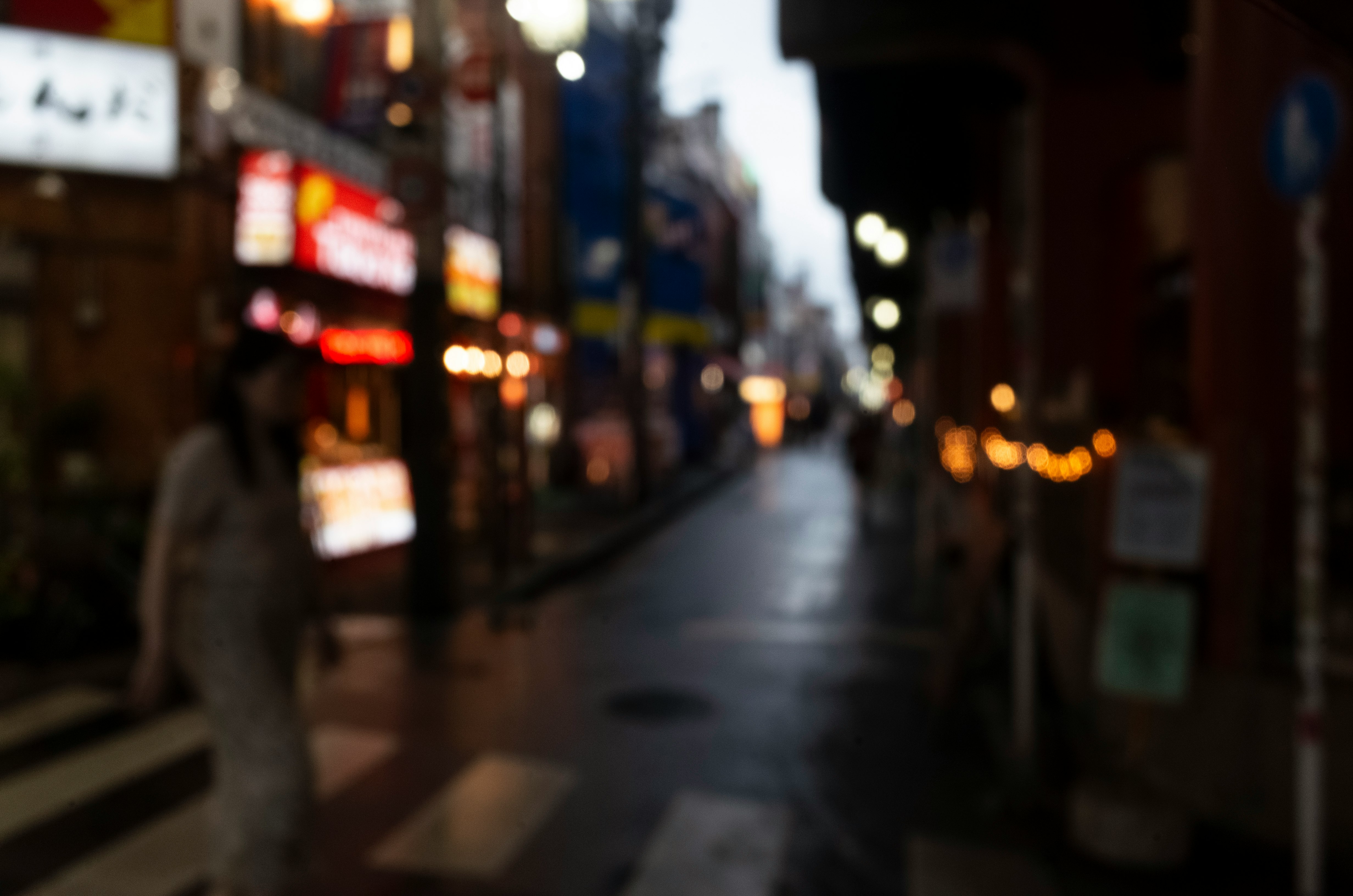 夜の路地に並ぶ看板と街灯の光