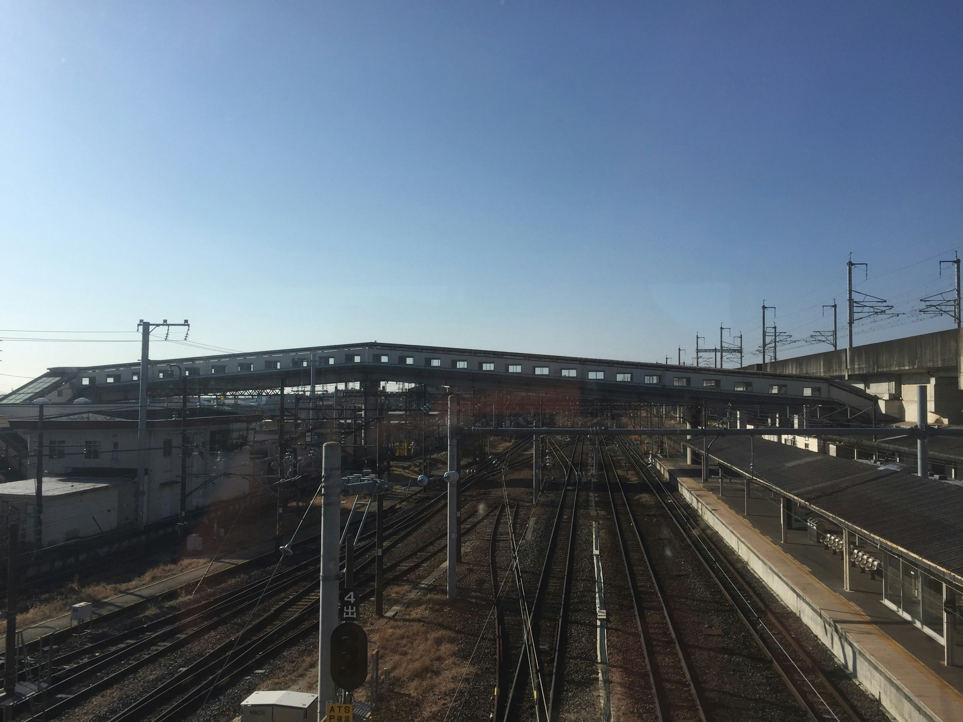 線路が伸びる駅のホームと高架のある風景