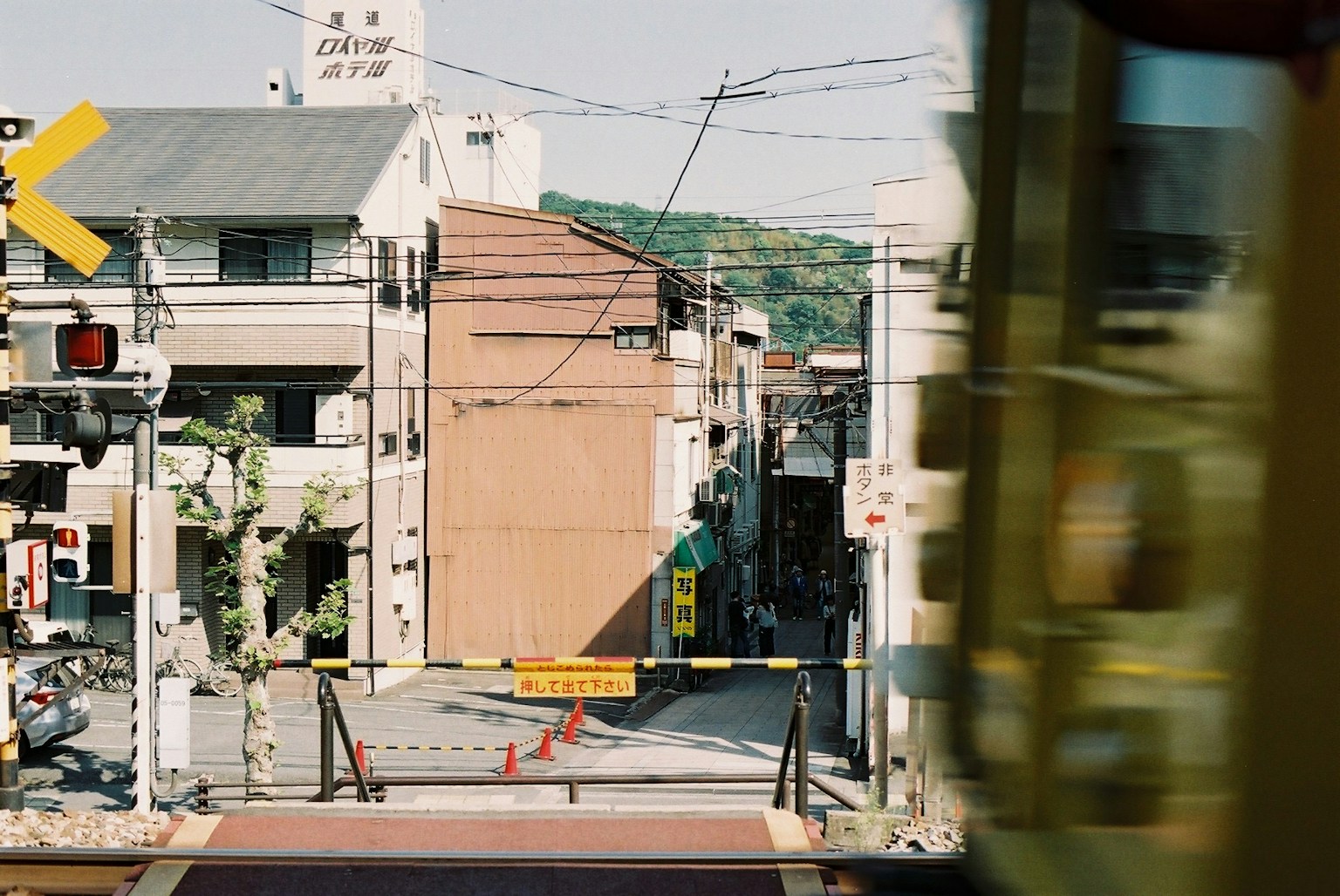 Street view with a railway crossing and a passing train