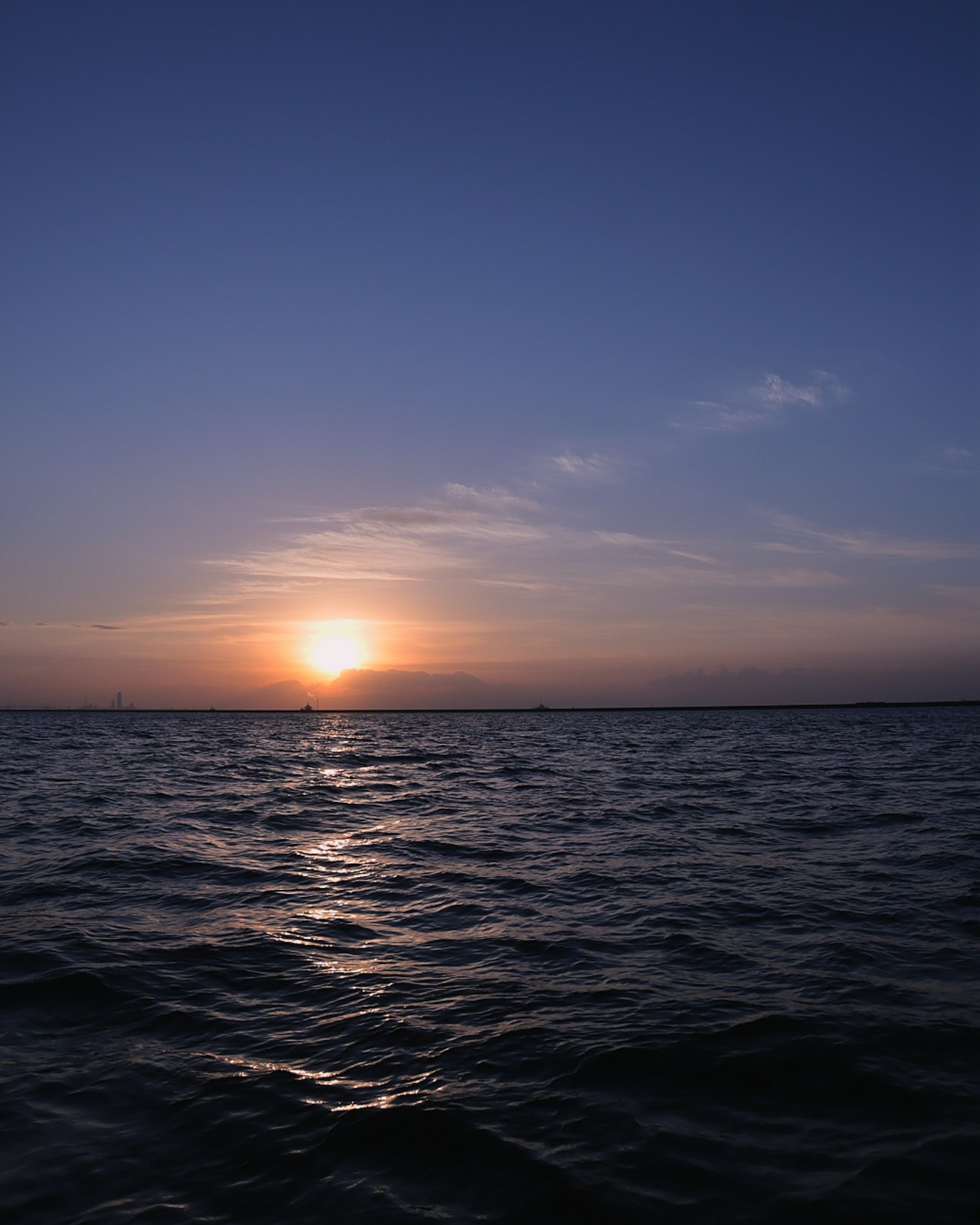 Sunset over the ocean with a blue sky