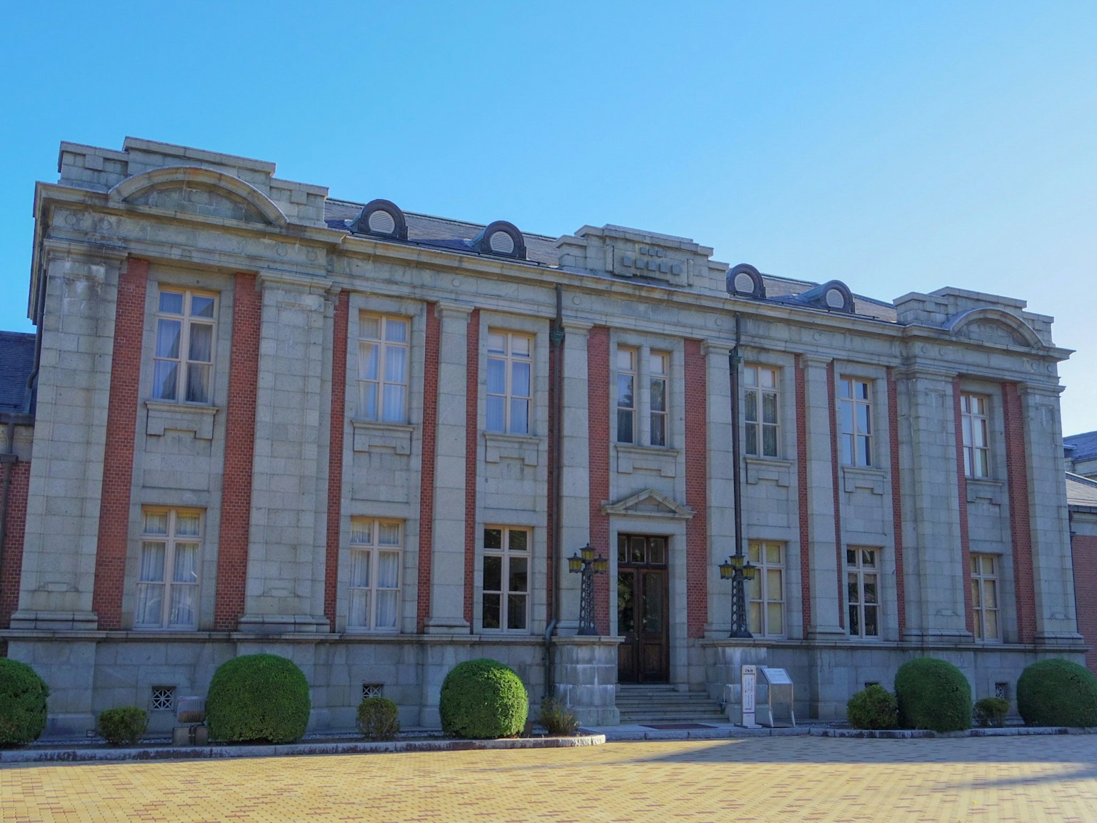 Facciata di un edificio storico con colonne ed elementi decorativi sotto un cielo azzurro