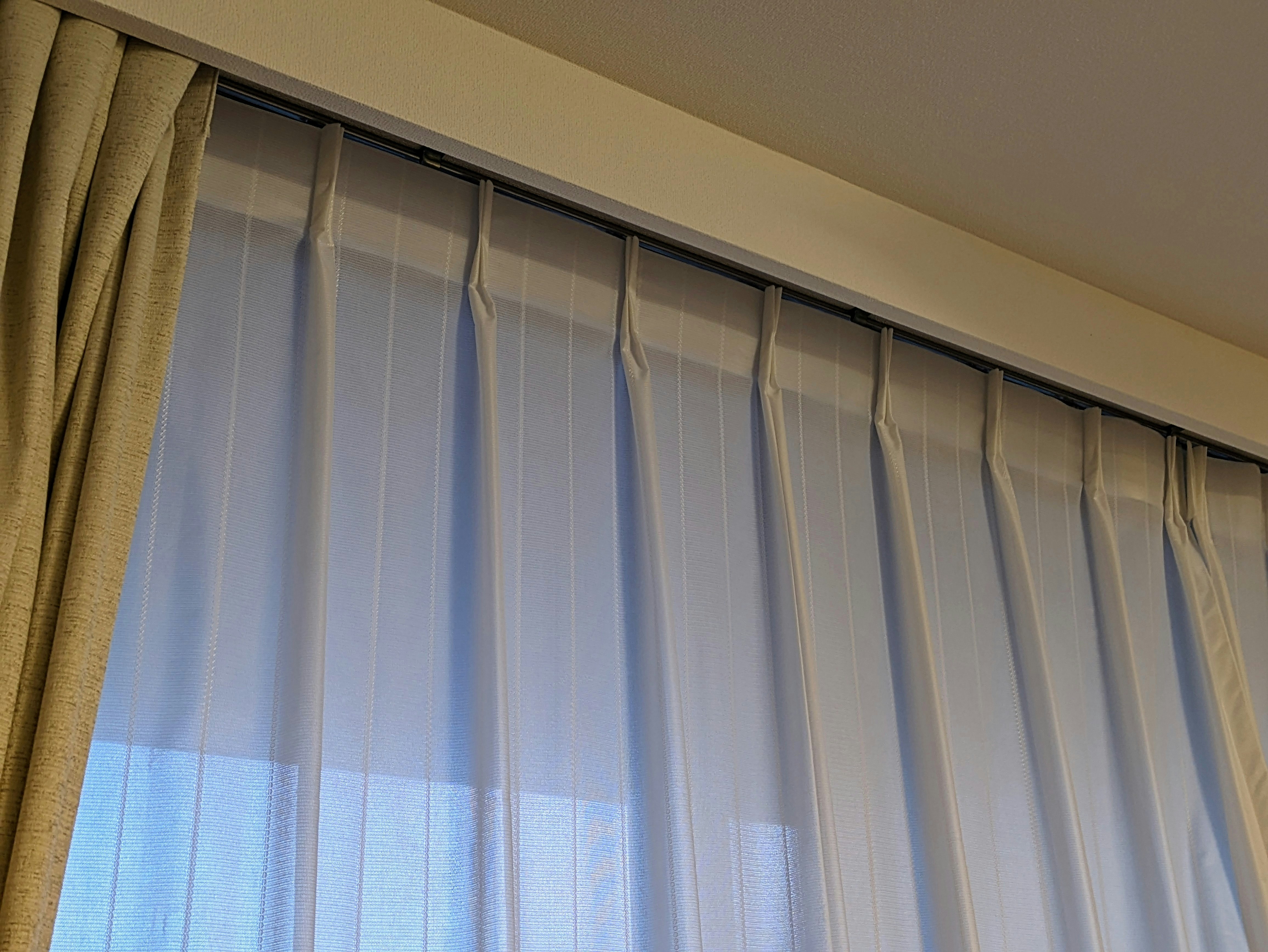 暗くなり始めた時間のカーテンと窓辺