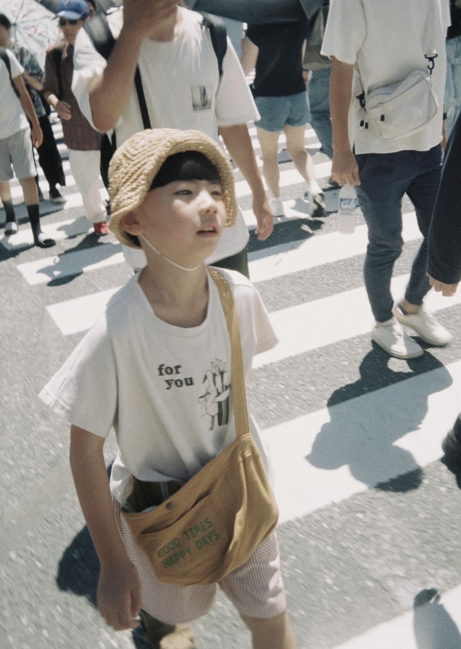 交差点を渡る子供の姿周囲には多くの人々がいる