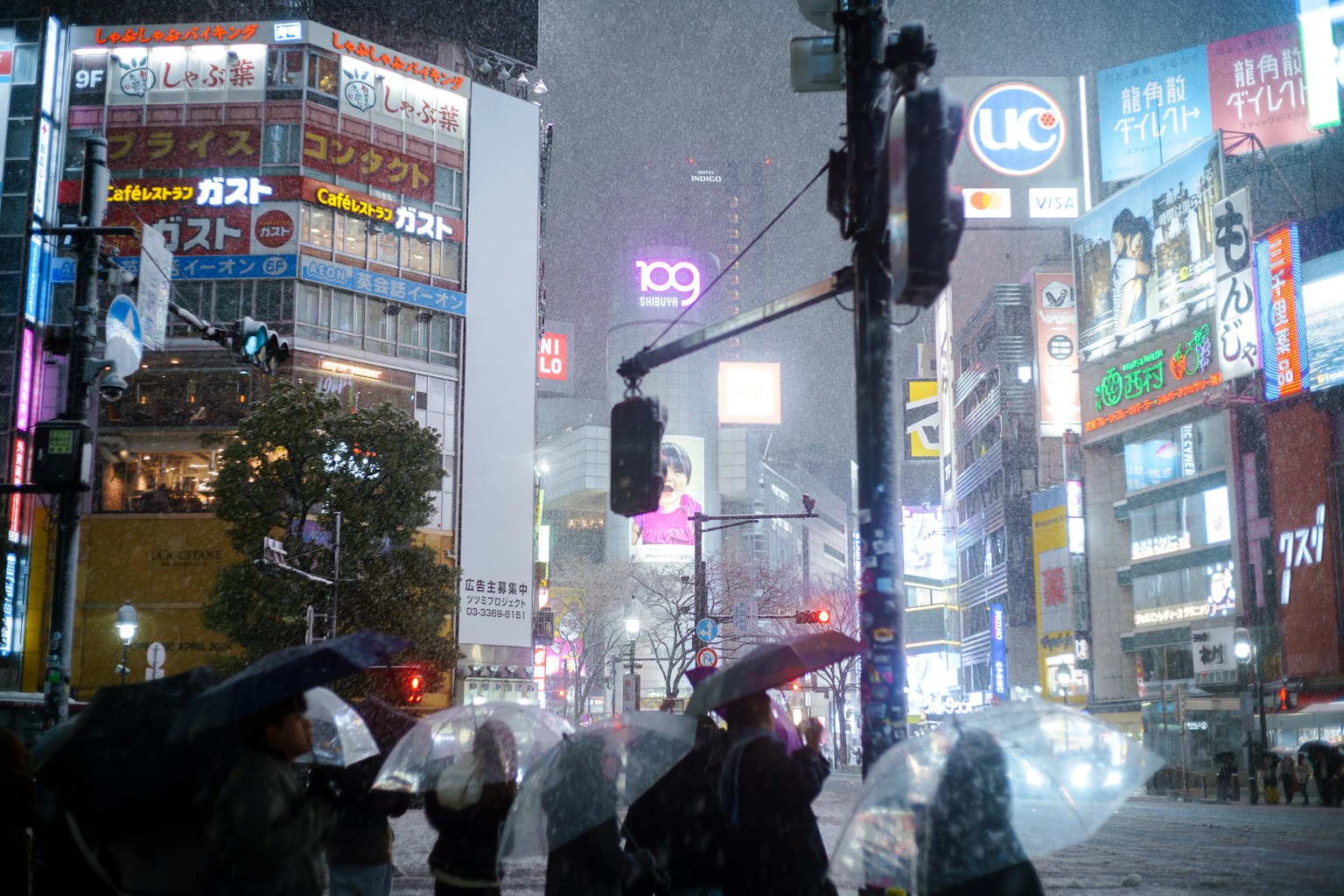 Stadtansicht mit Menschen, die im Regen Regenschirme halten und hellen Neonlichtern