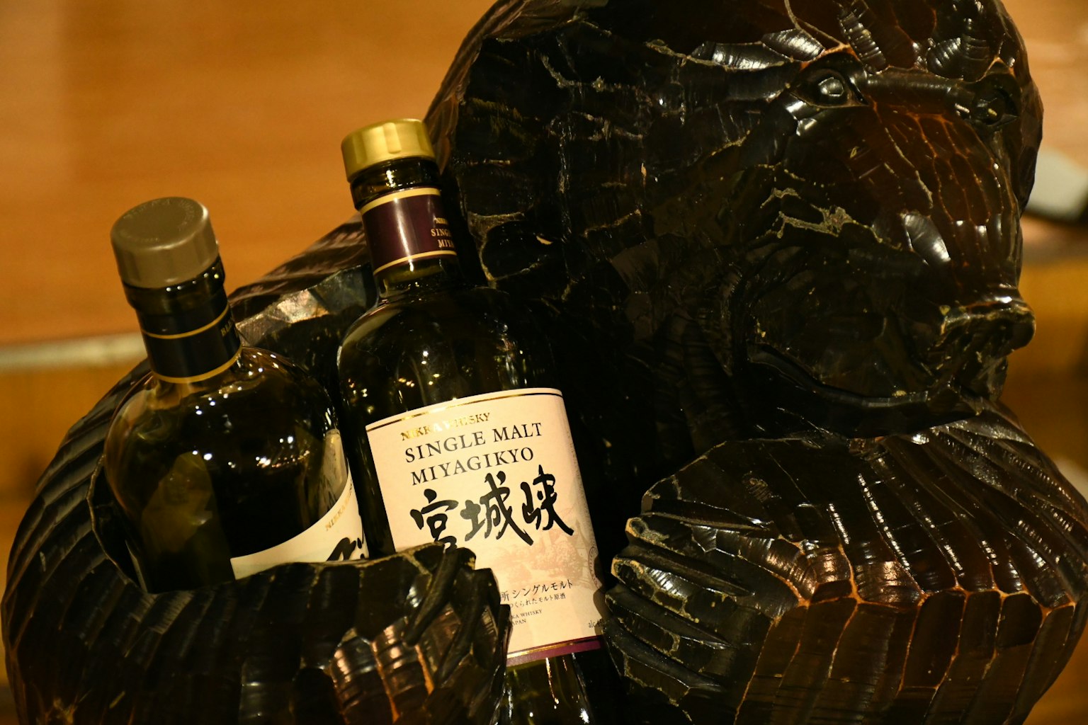 Whiskeyflaschen in einer Holzskulptur eines Bären