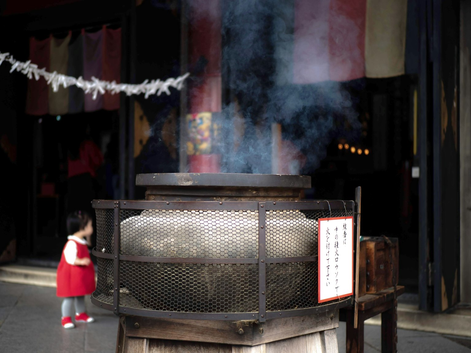 Nồi lớn tỏa khói với một đứa trẻ trong trang phục đỏ