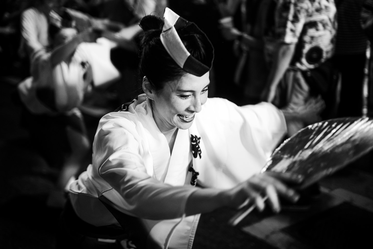 Una mujer con vestimenta tradicional sonriendo mientras actúa en blanco y negro