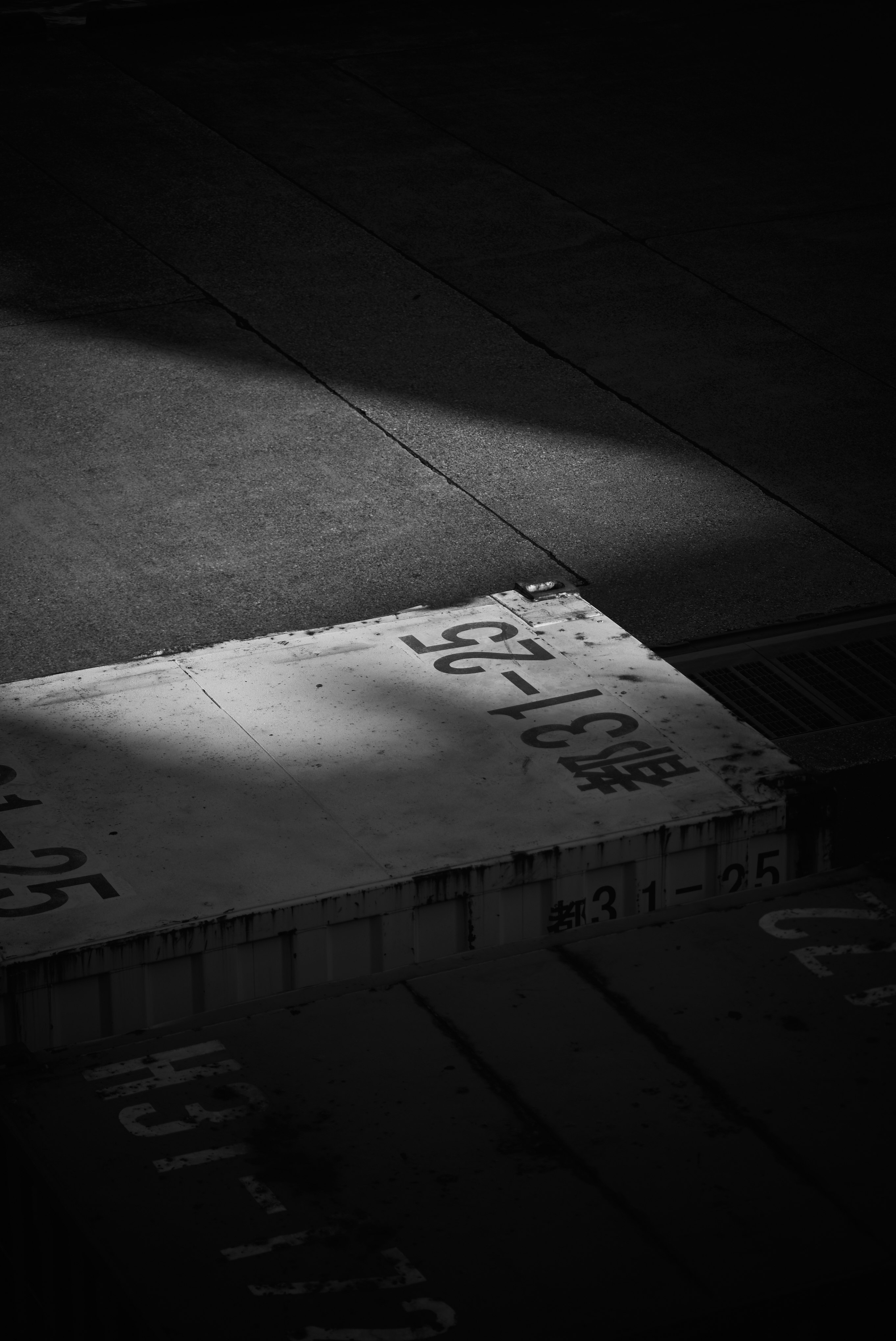 暗い路面に描かれた白い矢印と文字のある標識