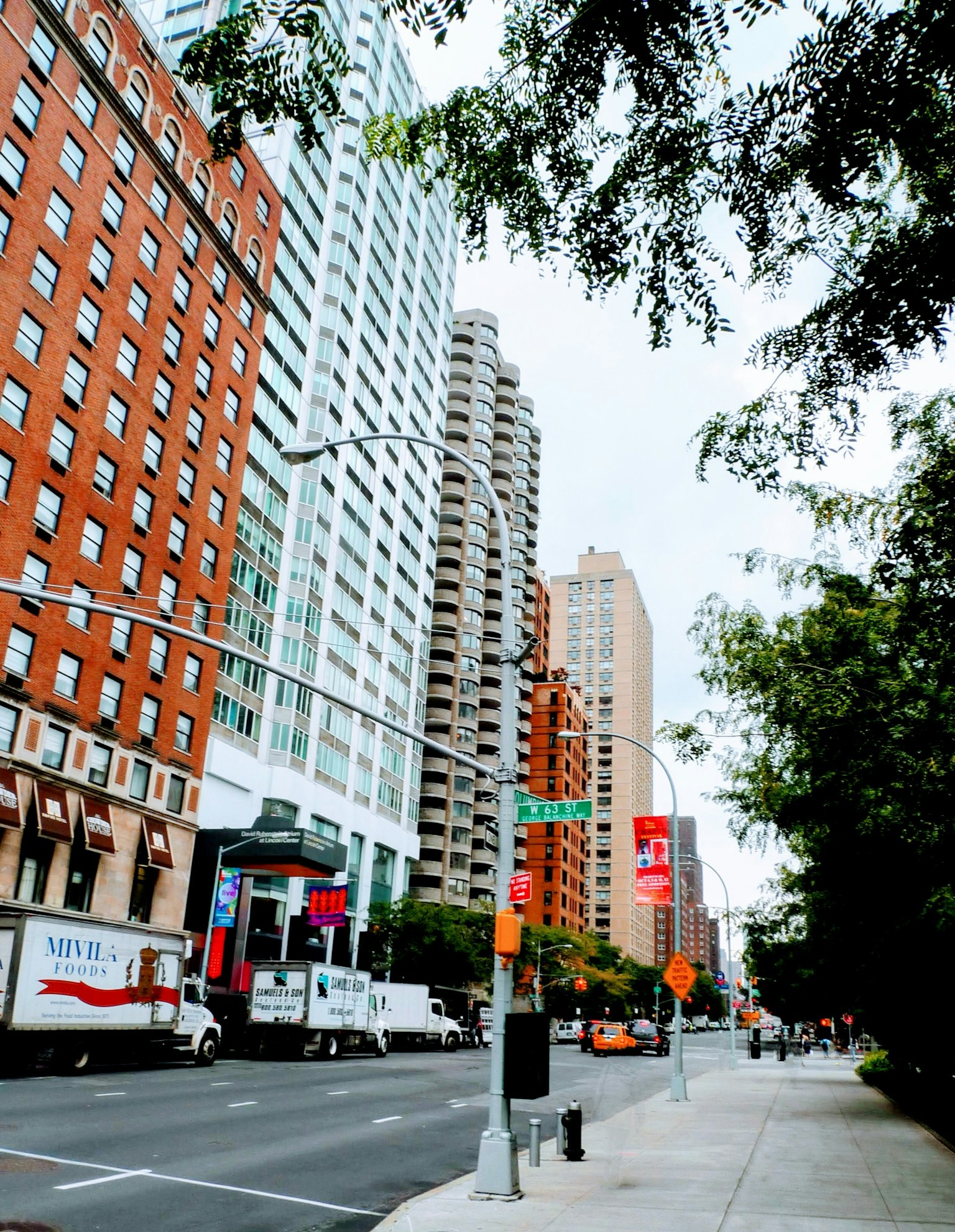 Escena urbana con edificios altos y árboles en la calle