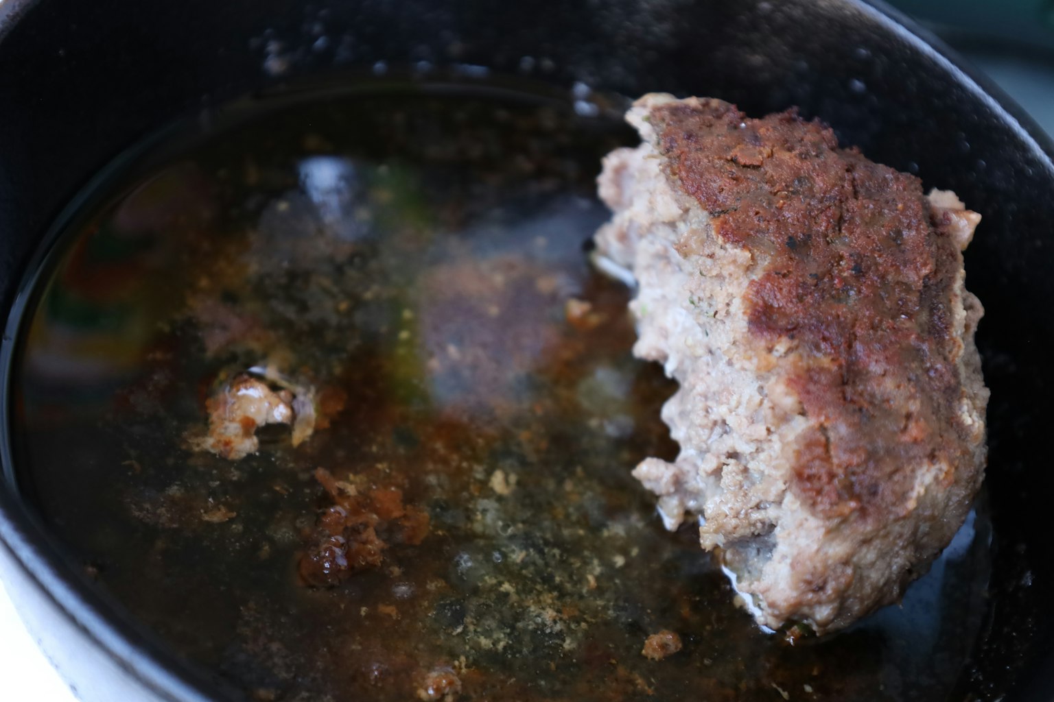 Ein Stück Hackbraten in einem Topf mit Brühe