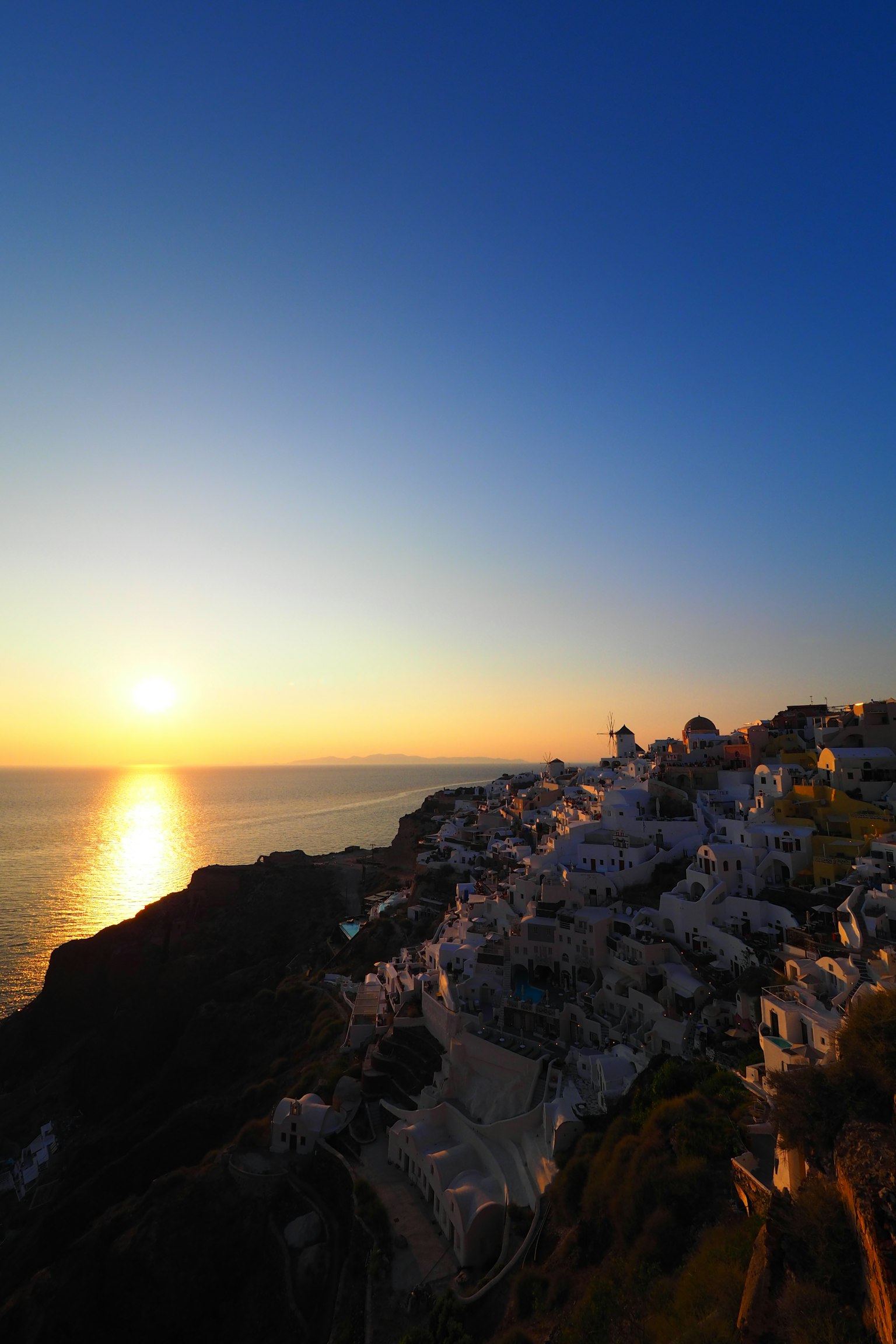 Hoàng hôn ở Santorini với các toà nhà trắng và bờ biển