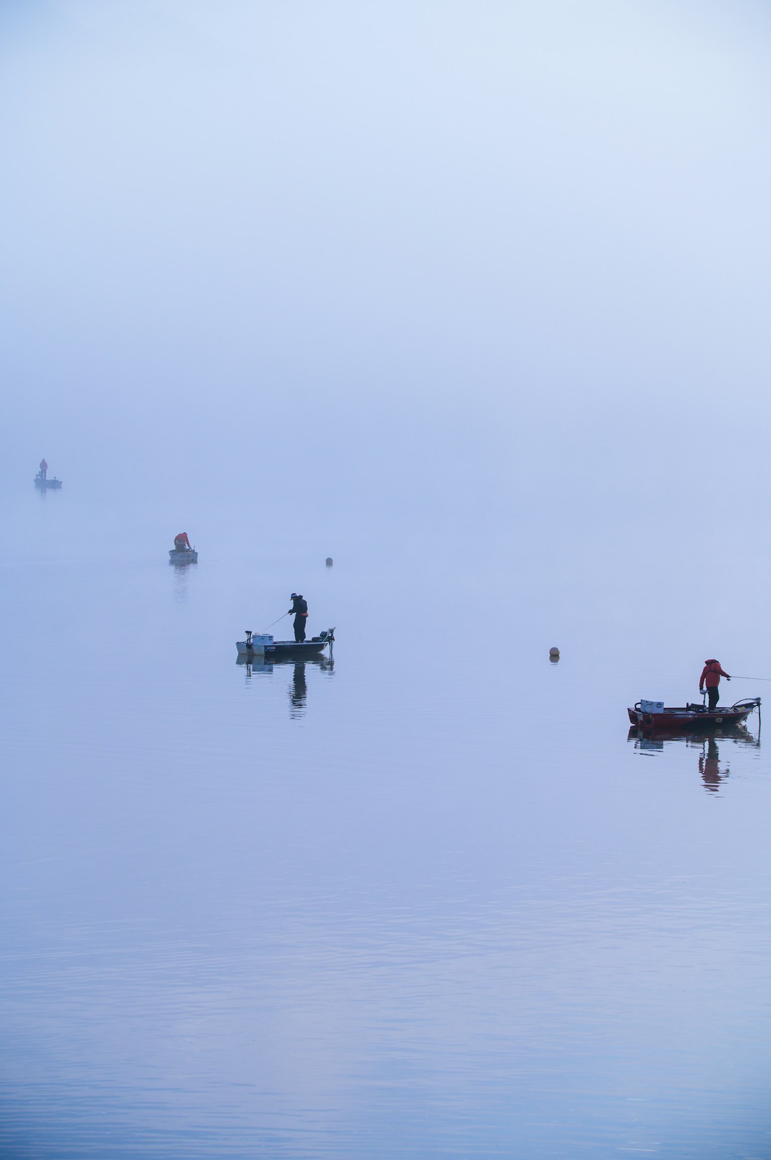 Serene scene of small boats fishing in the fog