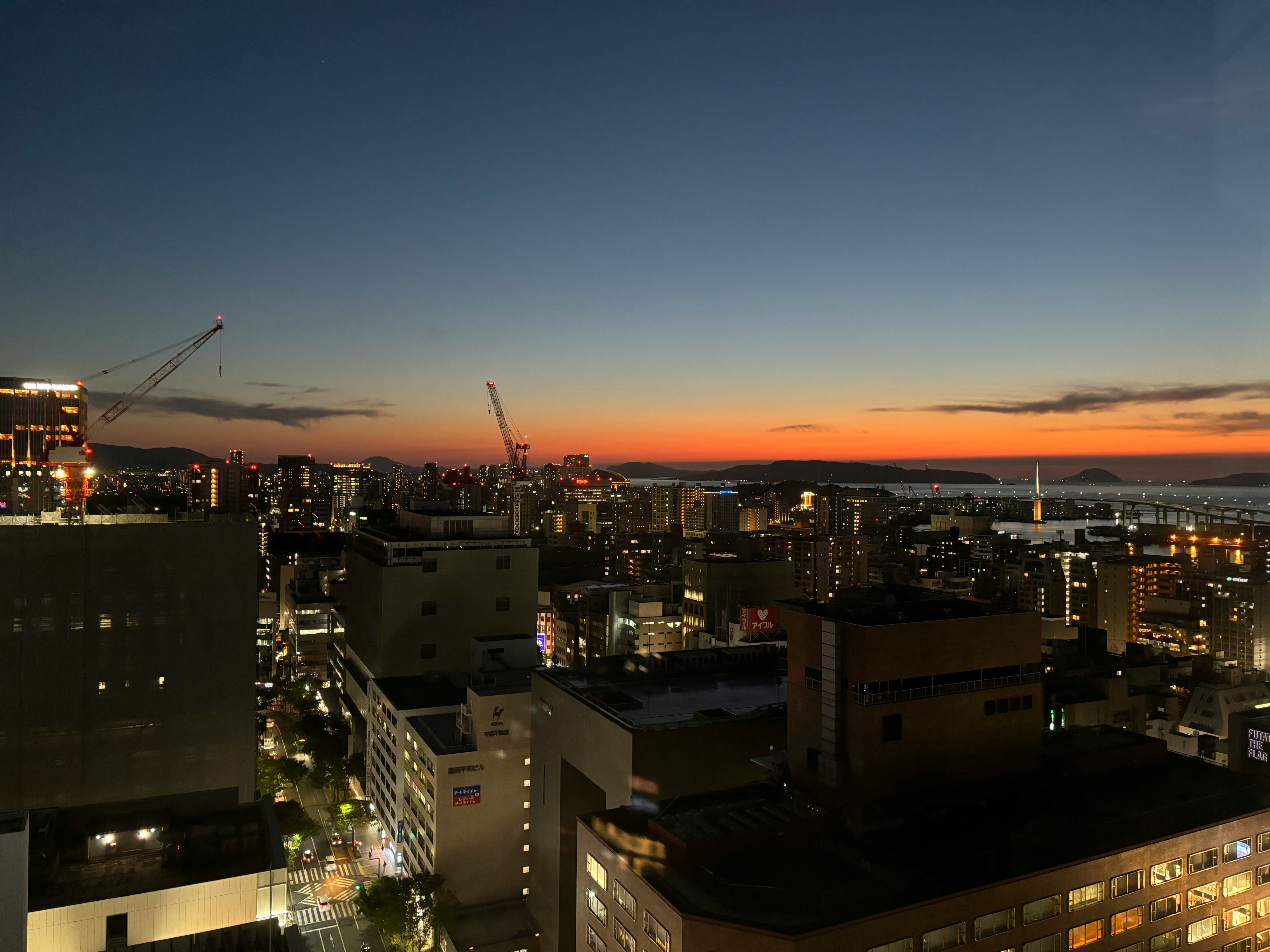 Skyline di Fukuoka al tramonto con luci notturne