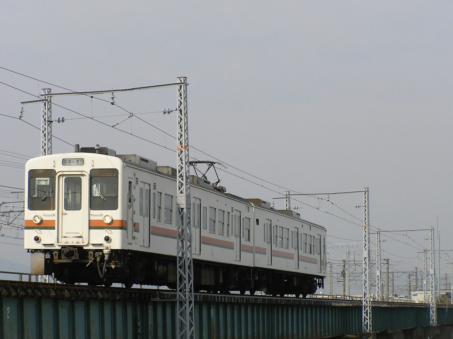 Un train blanc circulant sur une voie surélevée
