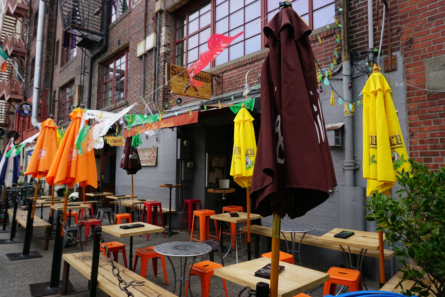 Extérieur d'un restaurant avec des parasols colorés et des places assises en plein air