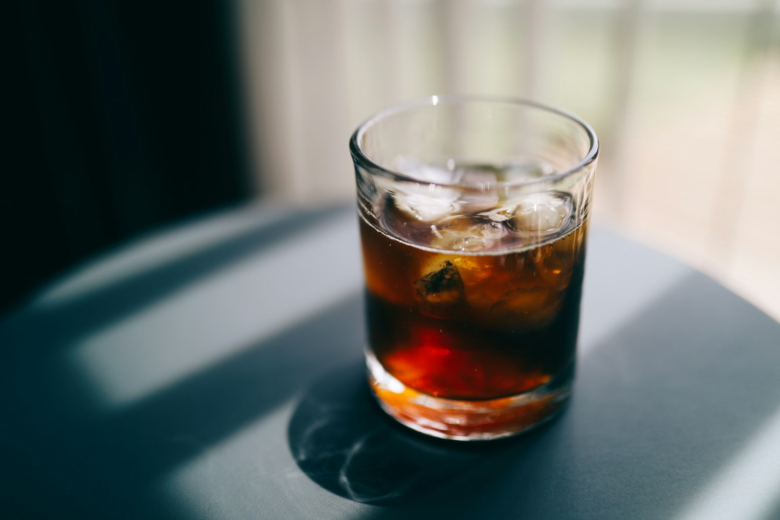 Un verre de boisson brune glacée sur une table
