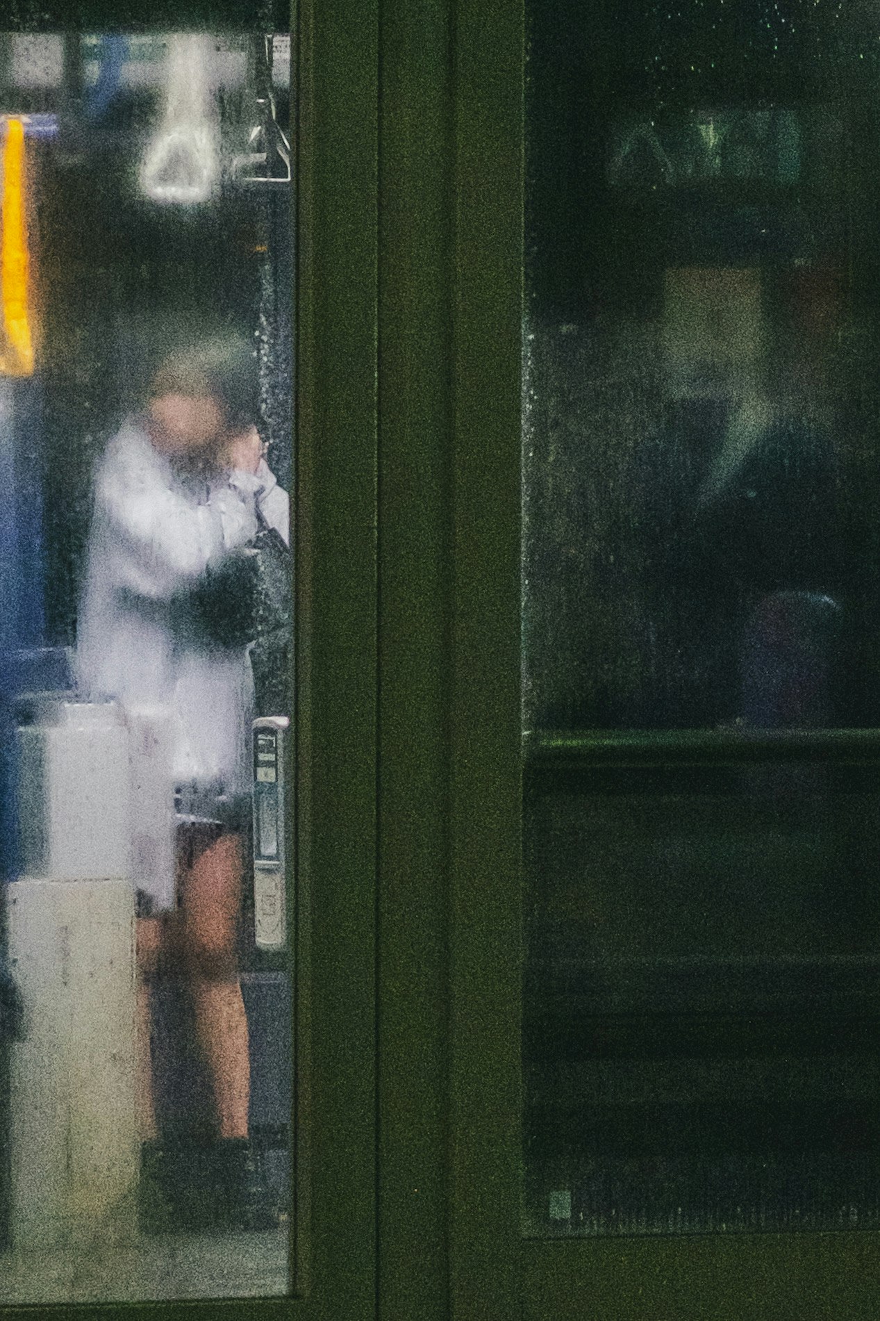 在雨中打电话的人在公交车站