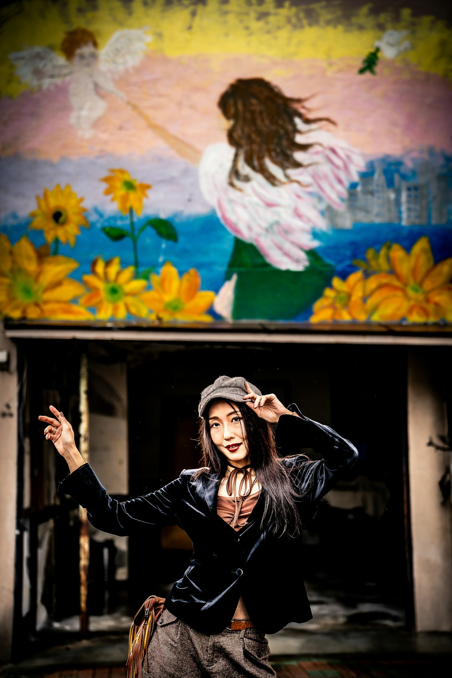 ผู้หญิงที่เพลิดเพลินกับแฟชั่นมีภาพจิตรกรรมฝาผนังสีสันสดใสอยู่ด้านหลัง