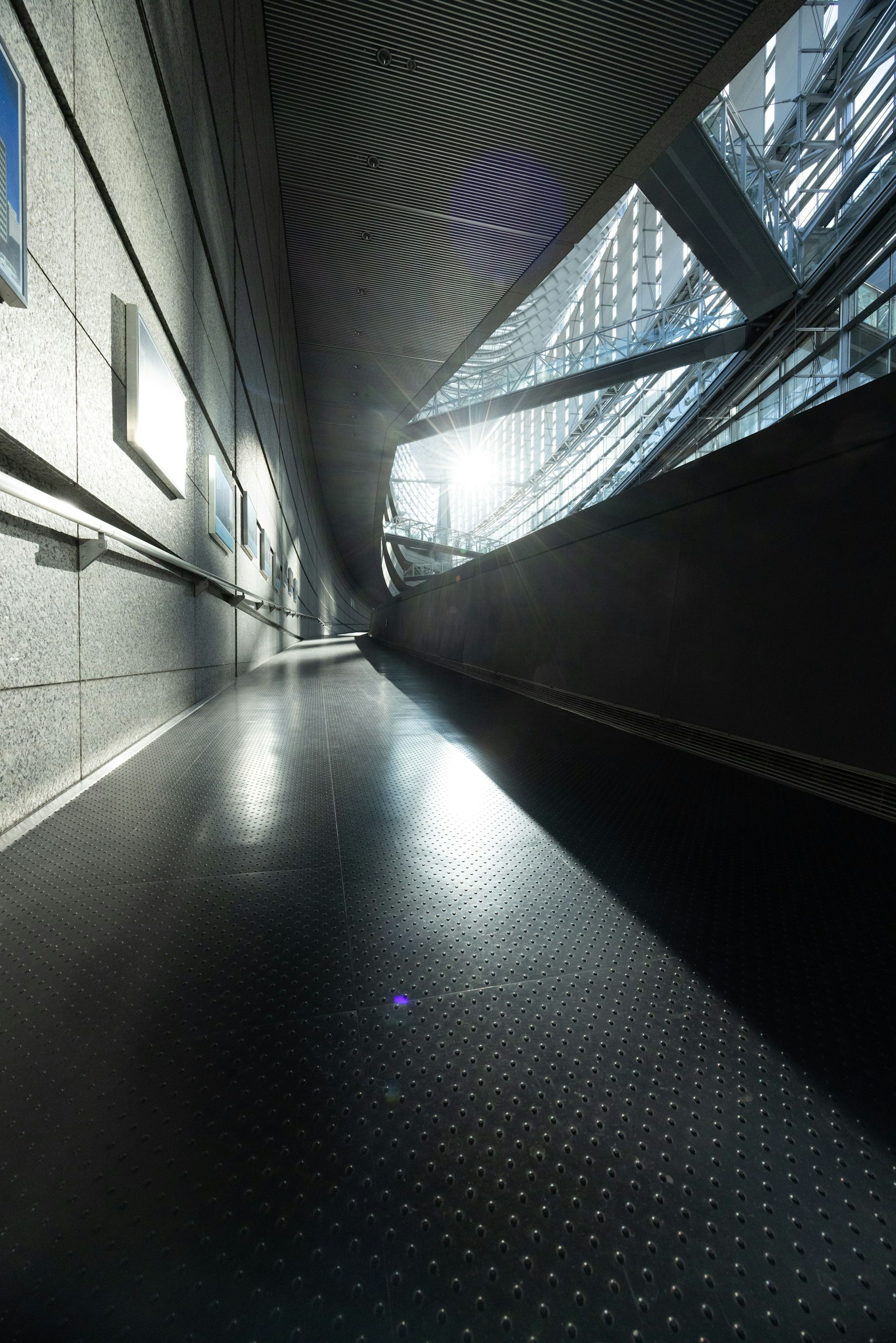 Lungo corridoio futuristico con luce che filtra attraverso finestre distintive