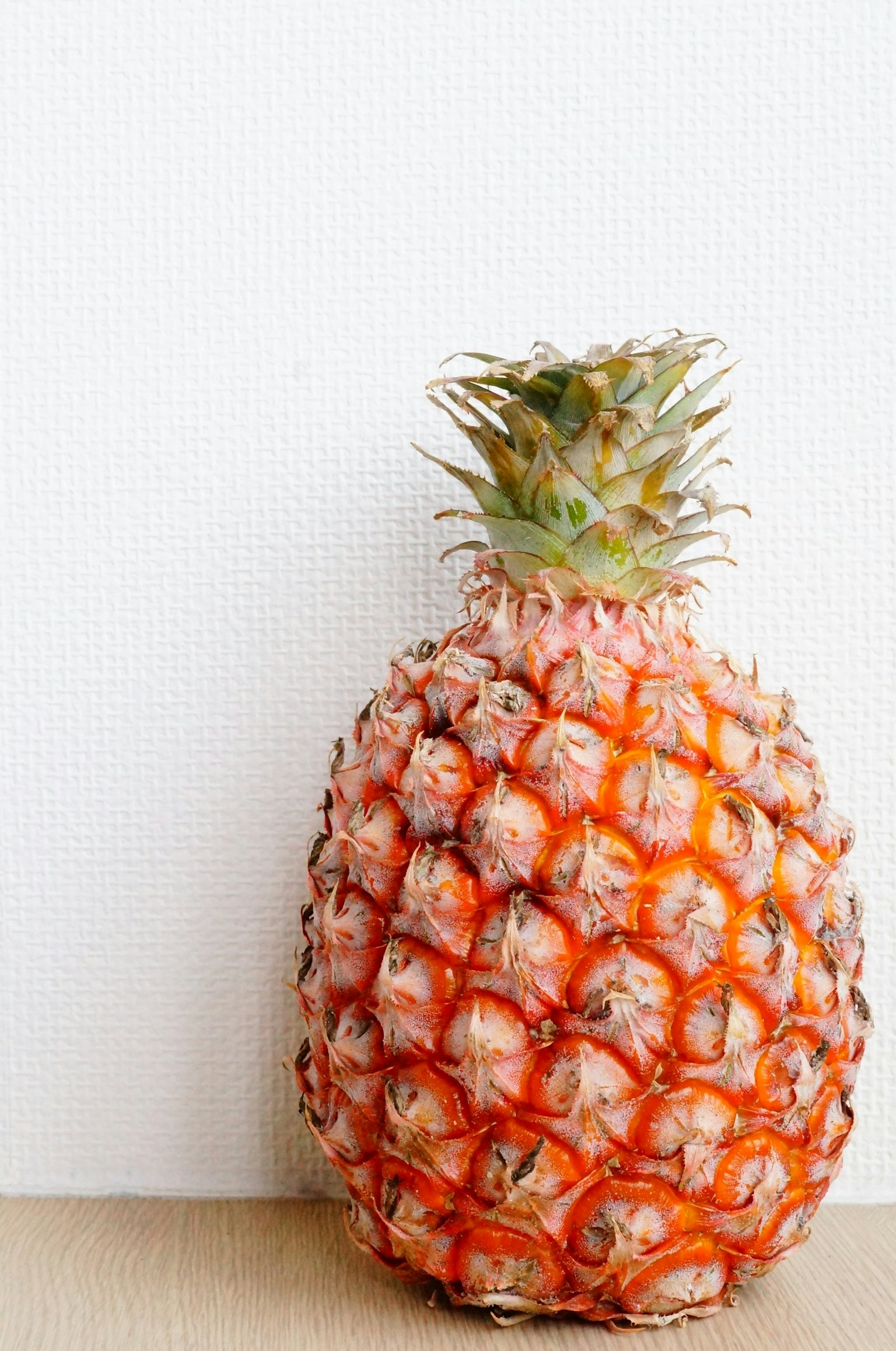 Una piña naranja vibrante contra un fondo blanco