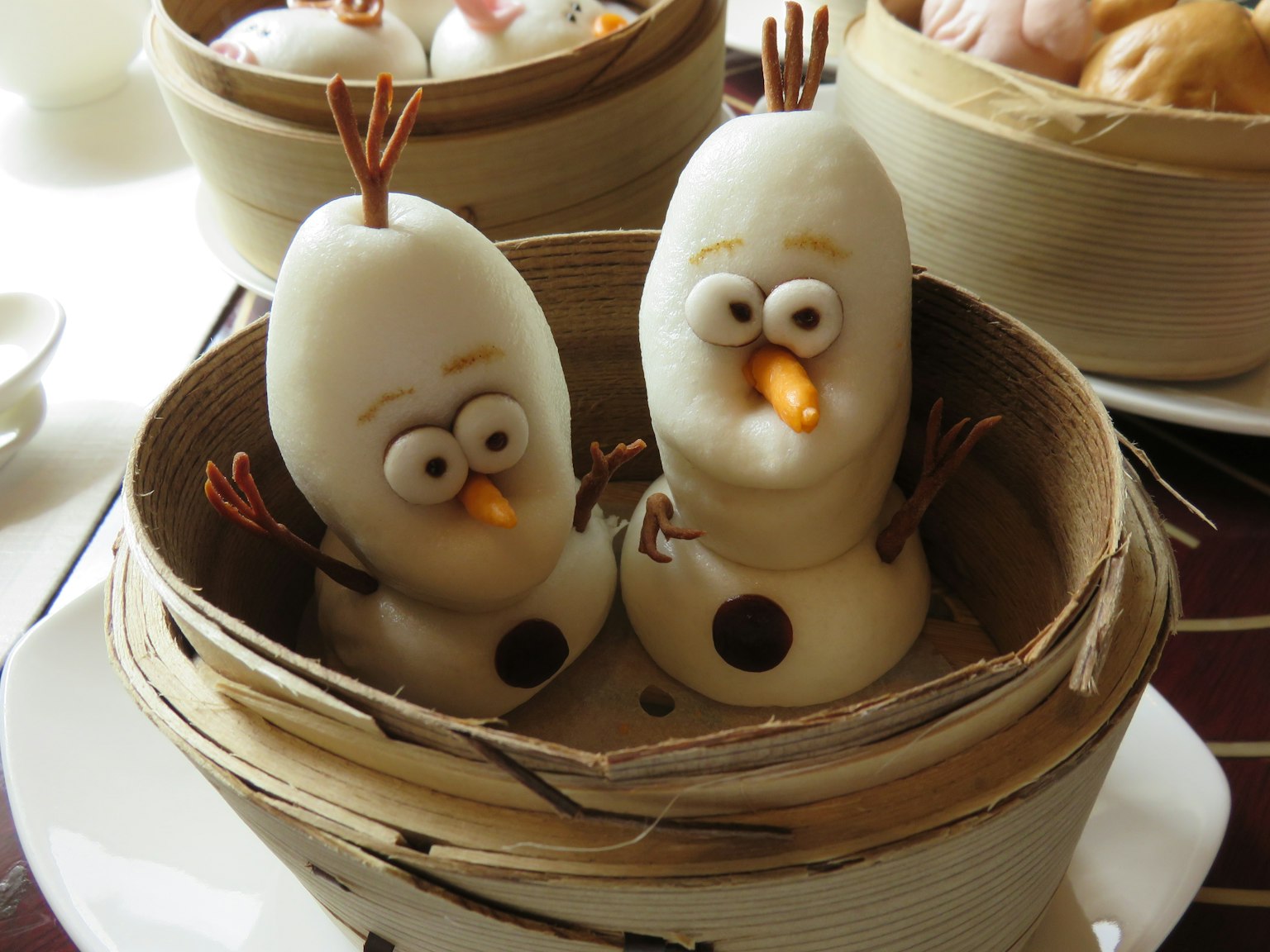 Bun al vapor en forma de Olaf, dispuestos en una cesta de bambú