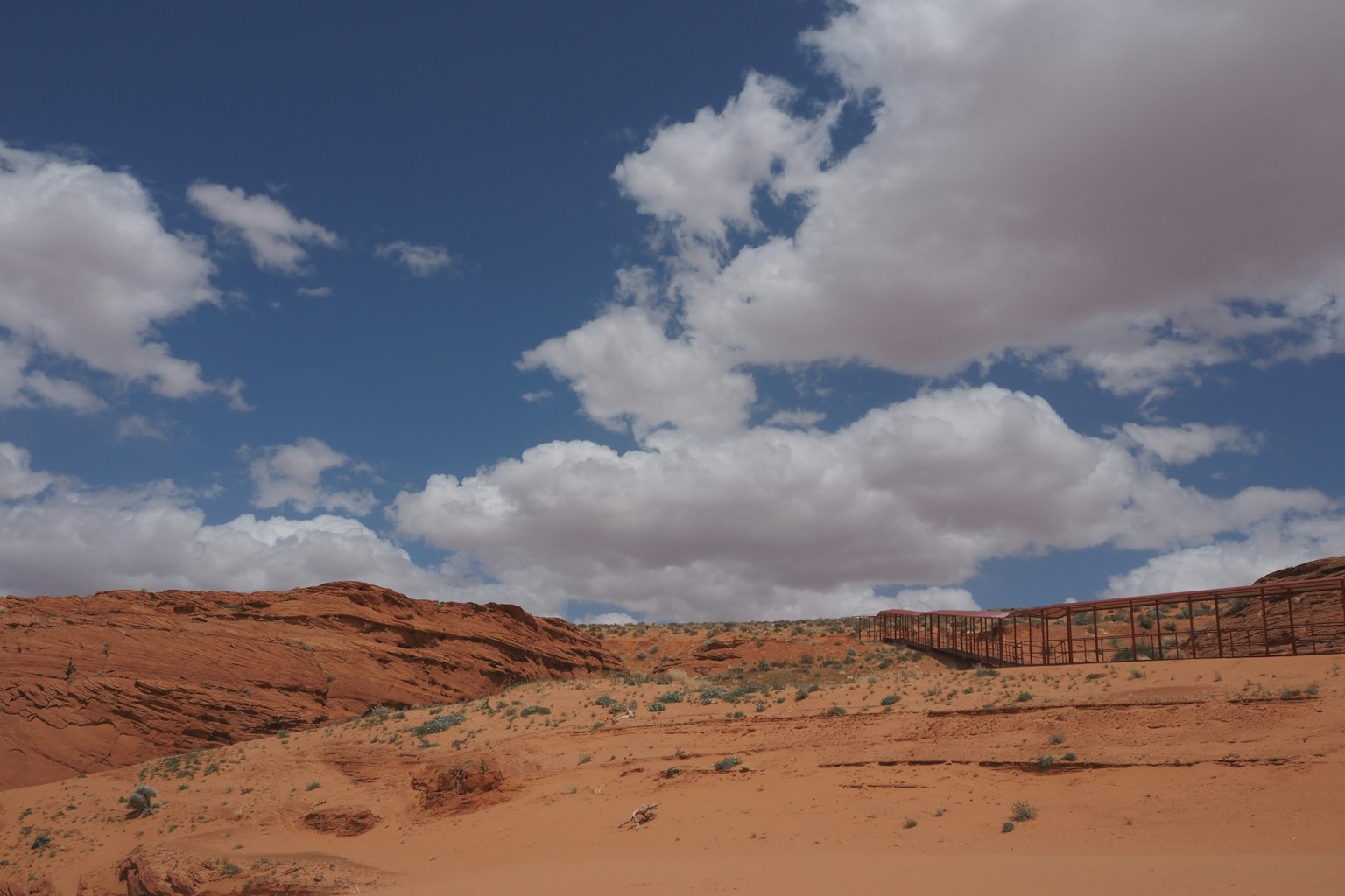 Paysage désertique rouge avec ciel bleu et nuages blancs moelleux
