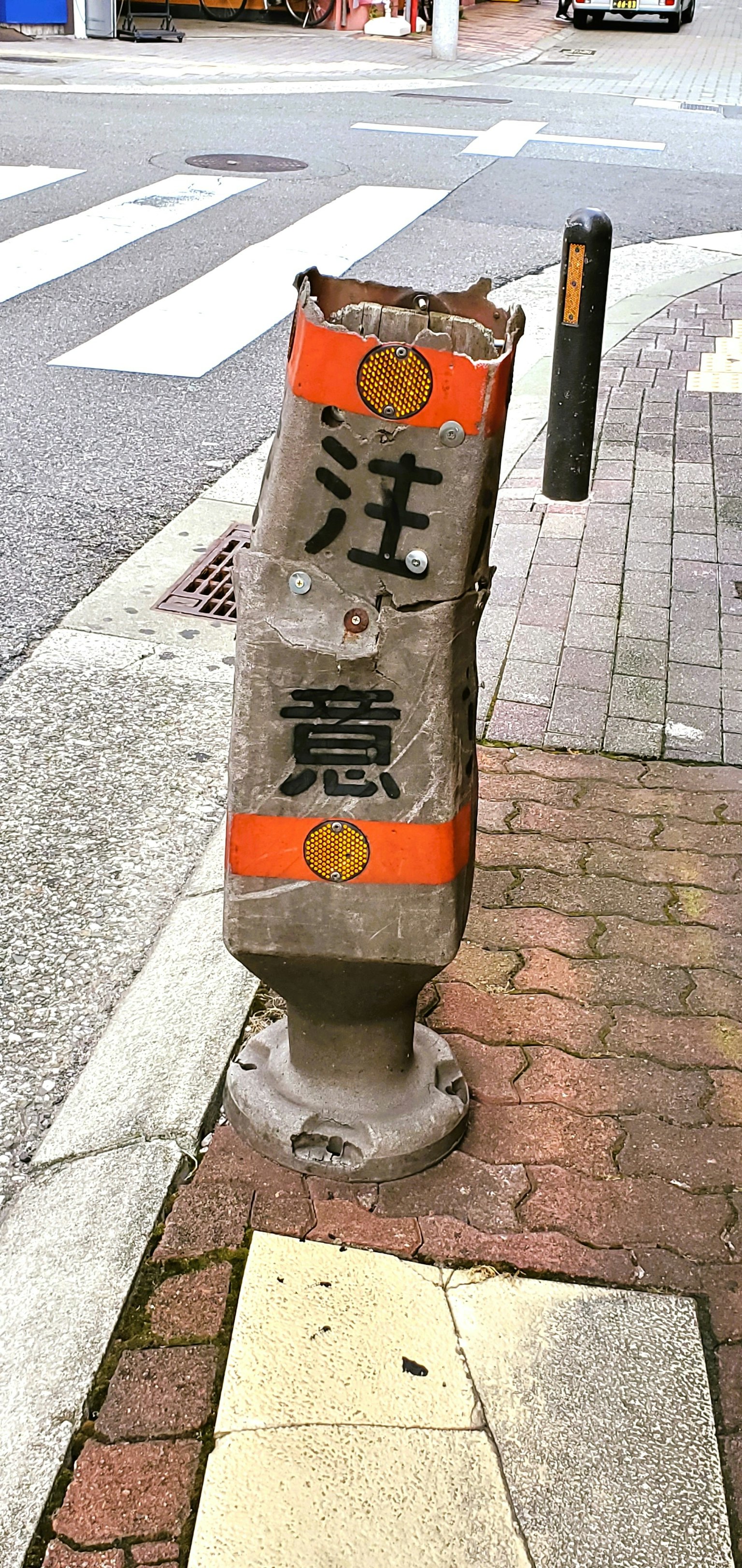 Beschädigtes Warnschild auf dem Bürgersteig