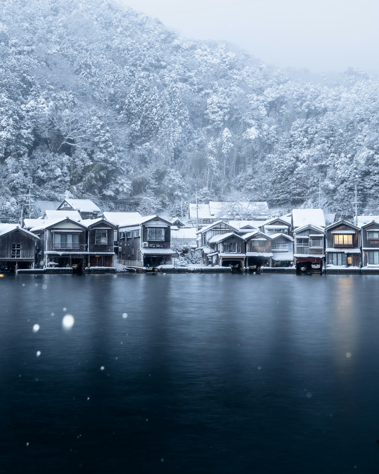宁静的湖畔场景，雪覆盖的小屋