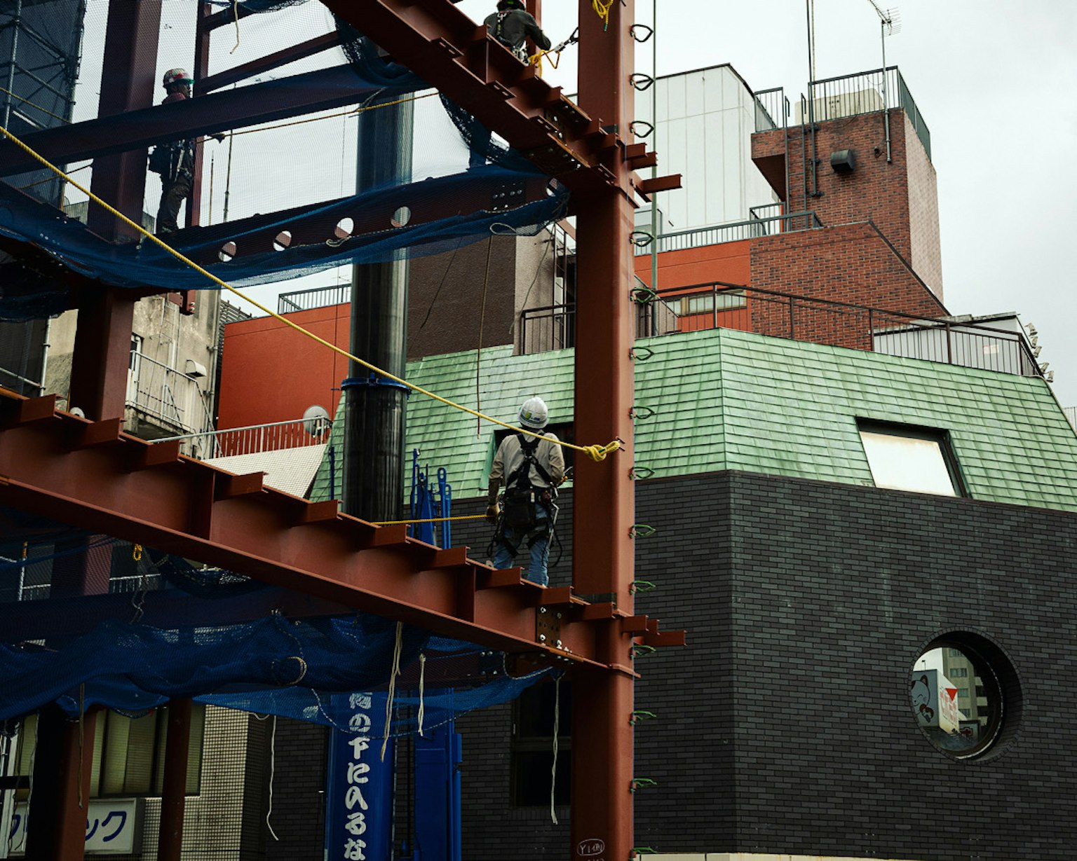 建筑工人在钢梁上，背景是现代建筑