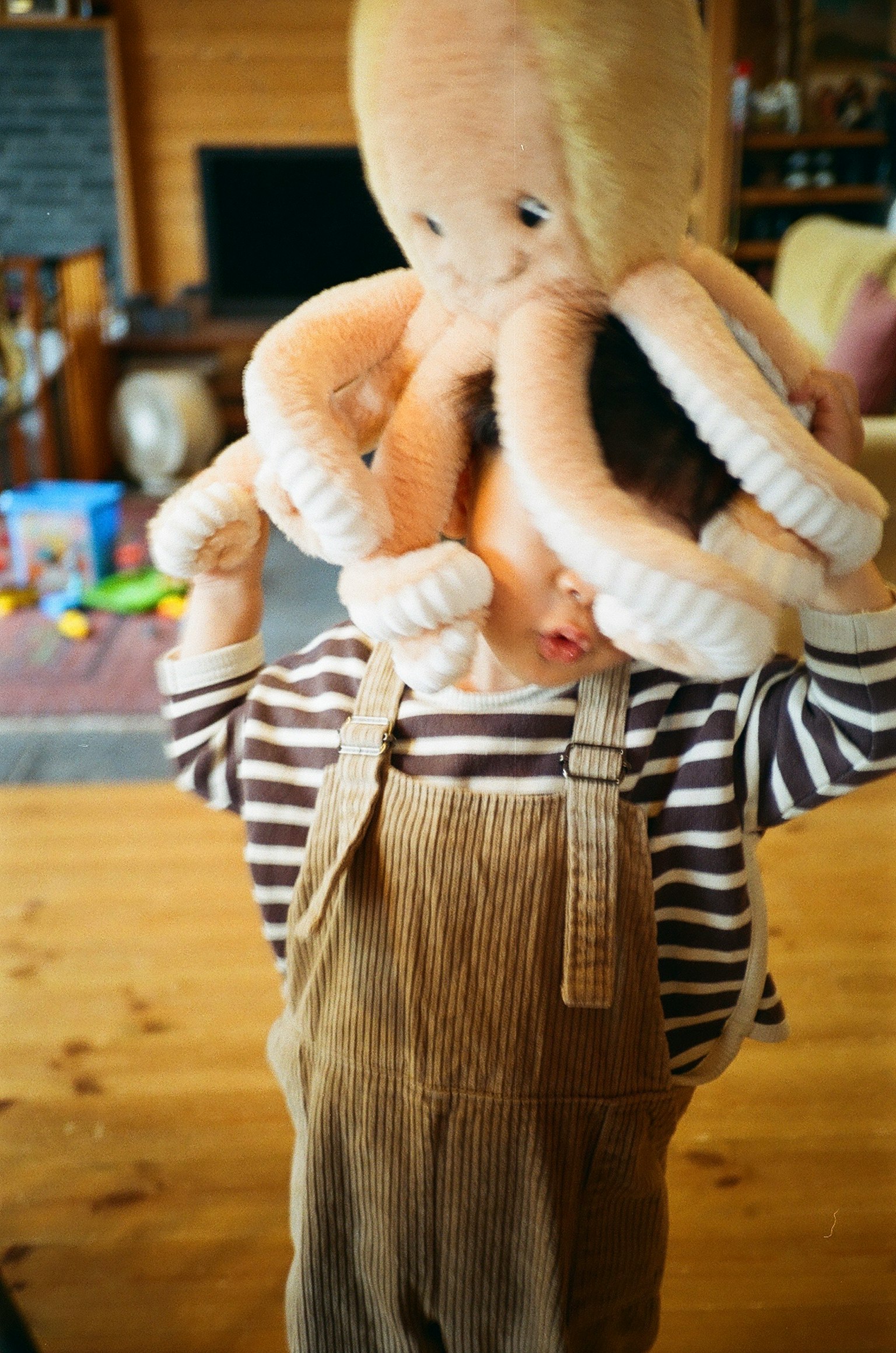 A child wearing an octopus plush toy on their head