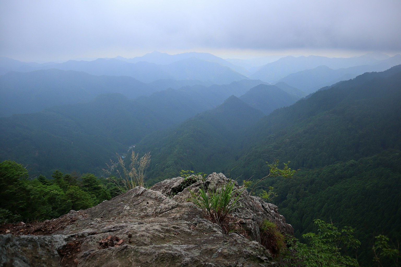 Vista da una roccia che sovrasta montagne nebbiose