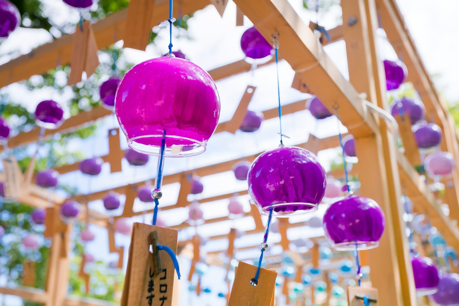 Foto de campanas de viento moradas colgando de una estructura de madera