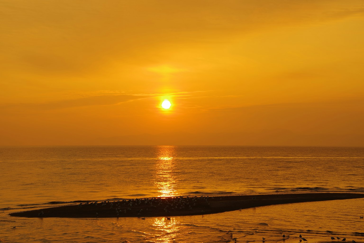 Bellissimo tramonto che si riflette sull'oceano con una tonalità arancione