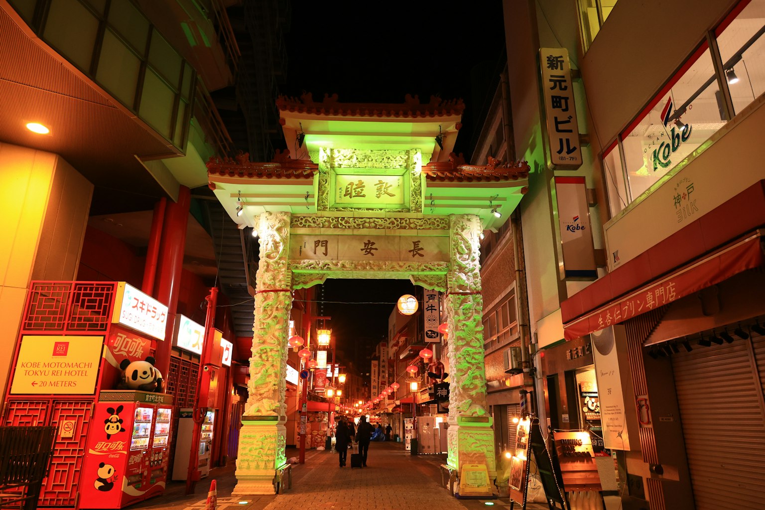 Vue nocturne de la porte en arc verte dans le Chinatown de Yokohama avec rue illuminée