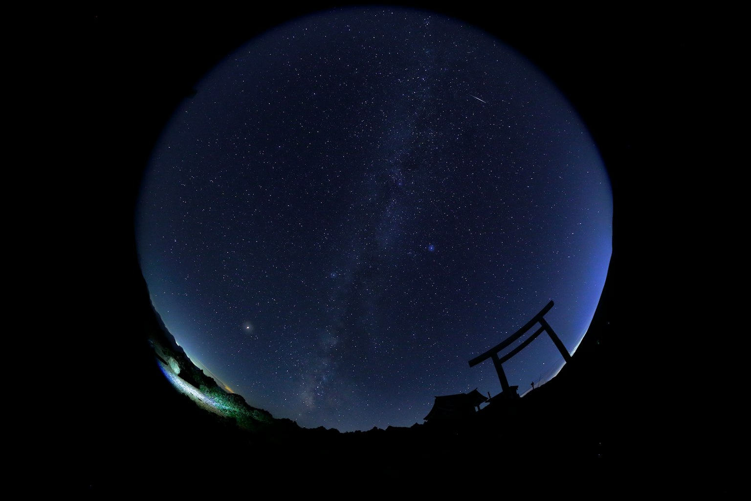 Langit malam dipenuhi bintang dan siluet gerbang torii