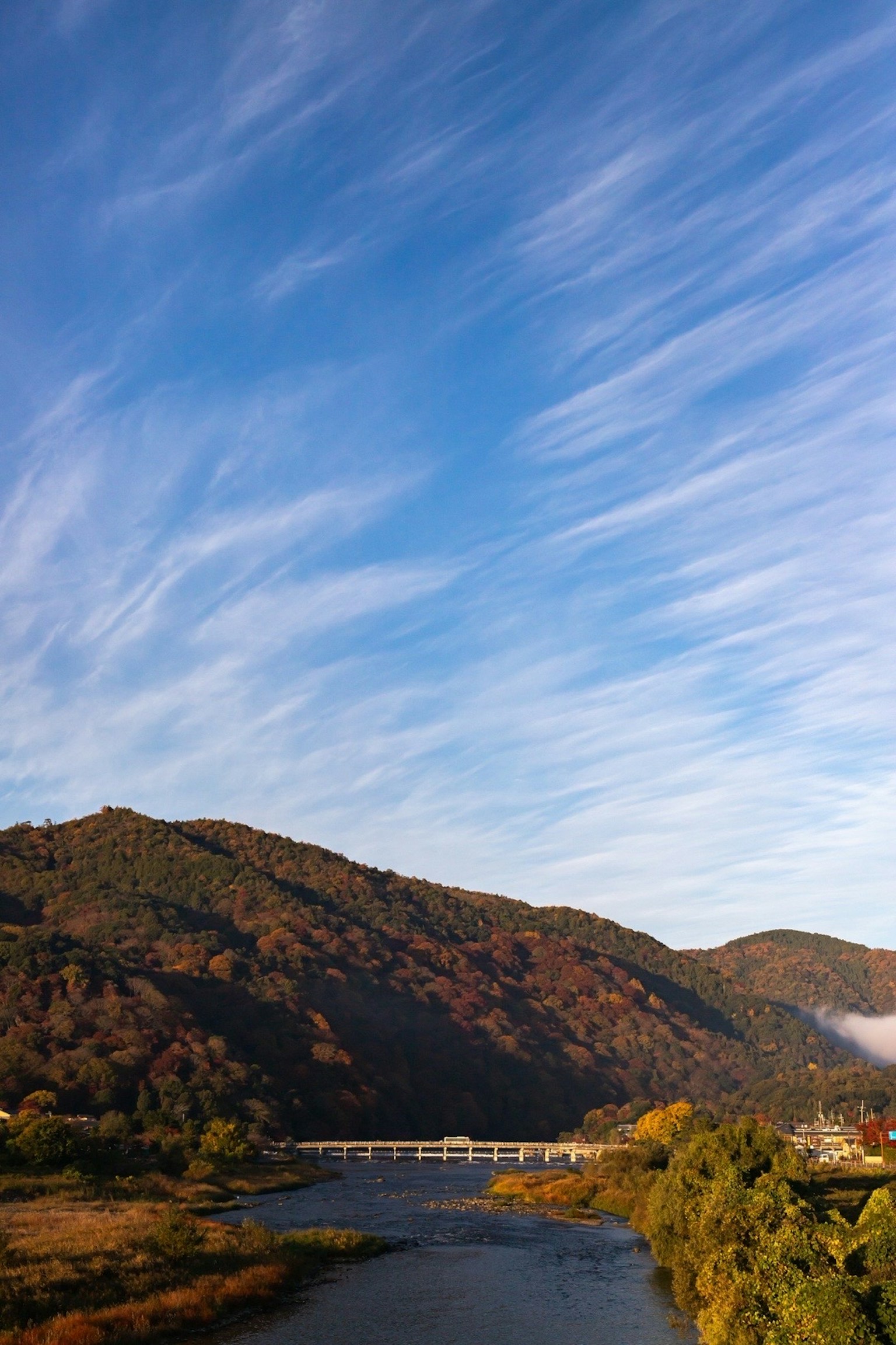 Autumn landscape with blue sky and clouds mountains and river harmoniously blending