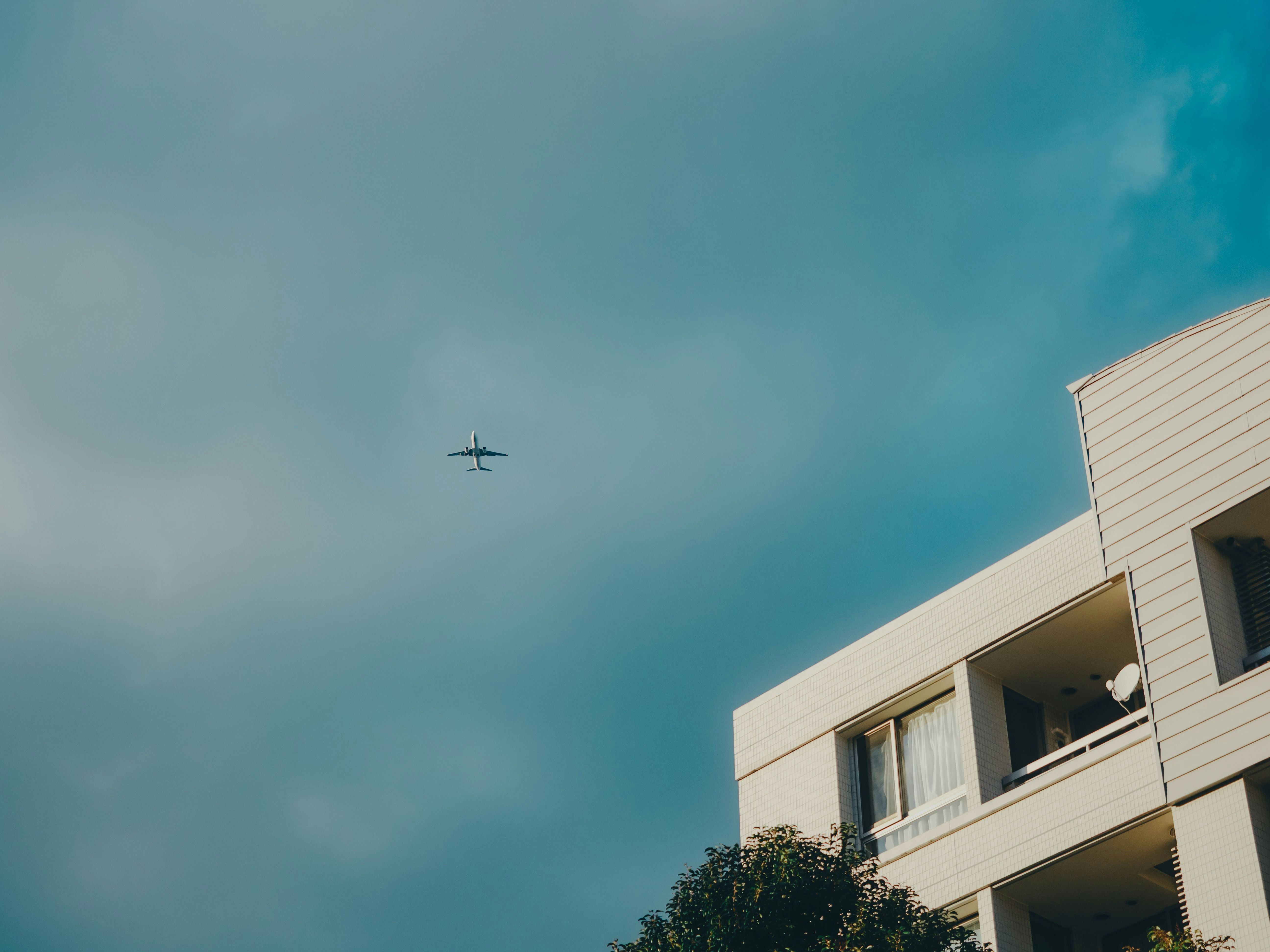 Vista del cielo con tetto di un edificio e aereo in lontananza