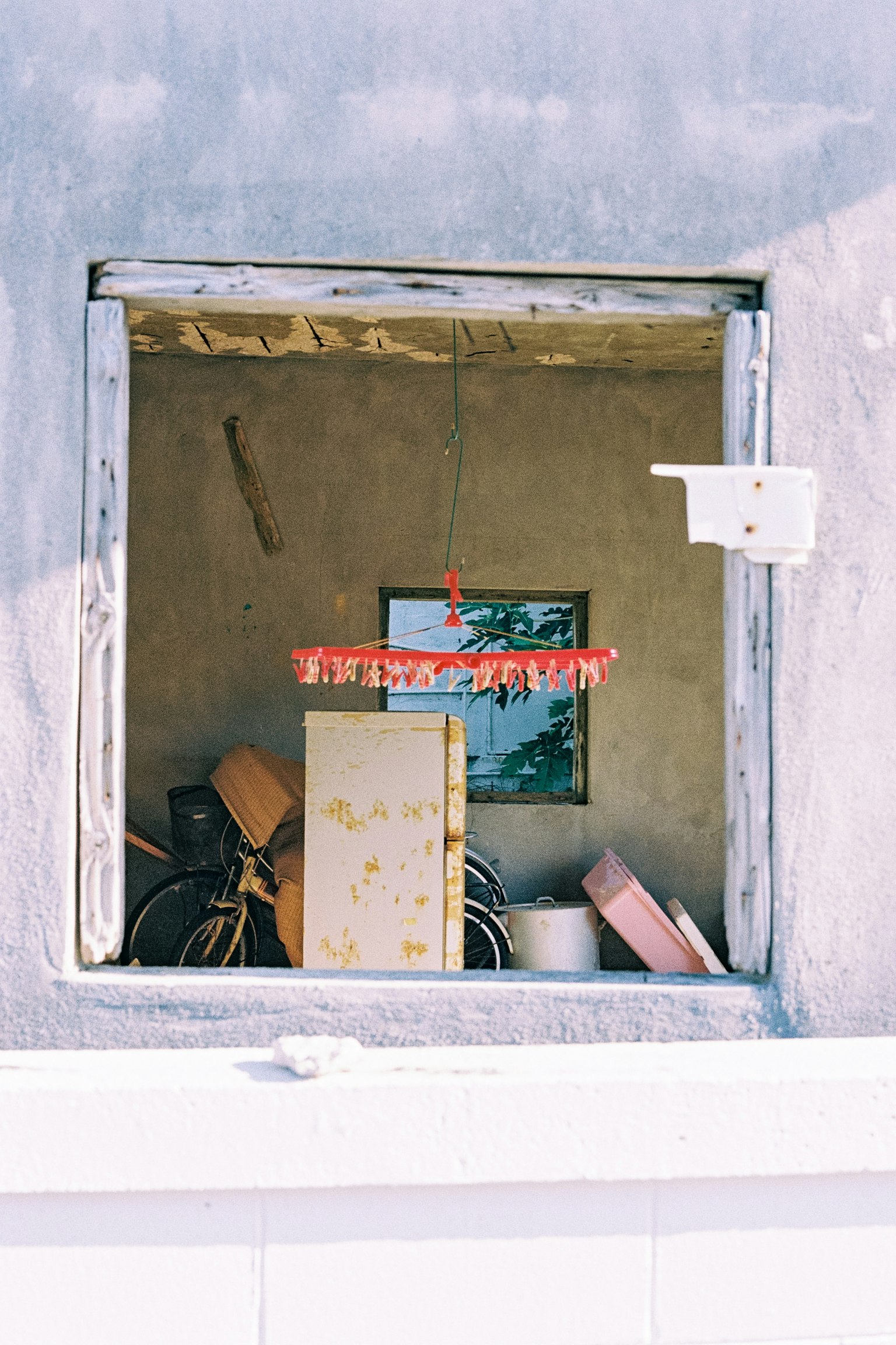 Espacio de almacenamiento desordenado visible a través de una ventana con un letrero rojo