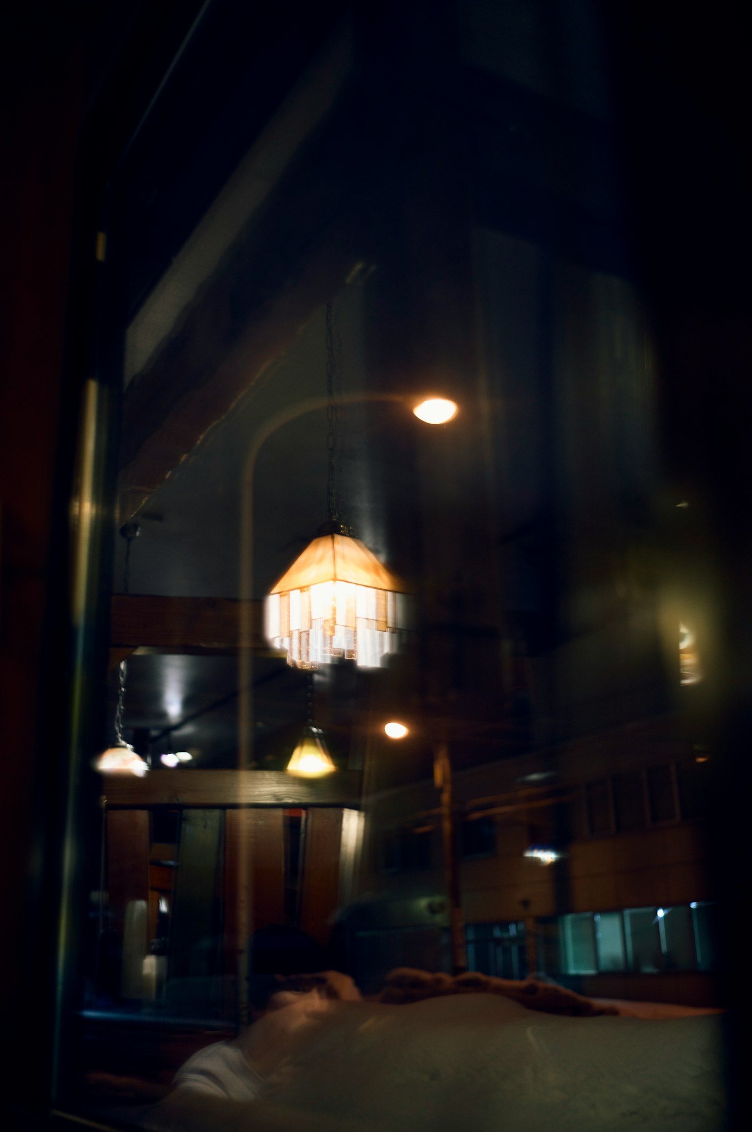 Suaves reflejos de una lámpara y luces ambientales vistas a través de una ventana