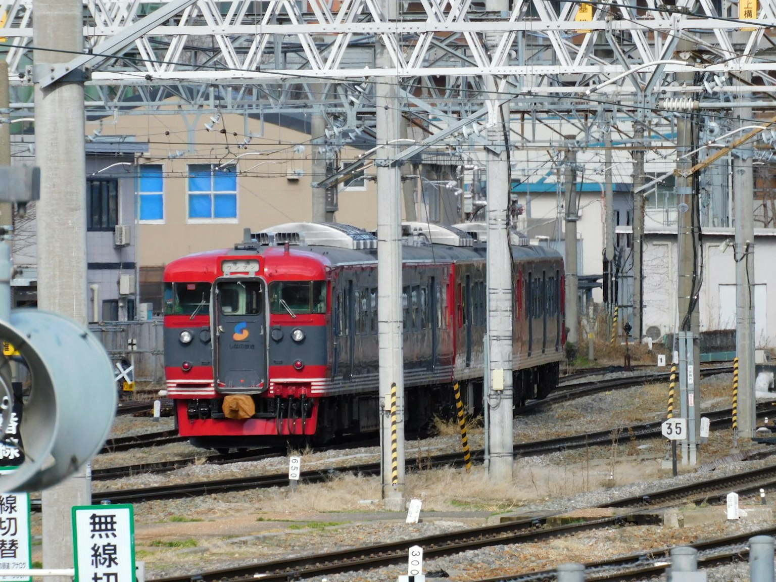 停靠在軌道上的紅色火車靠近建築物