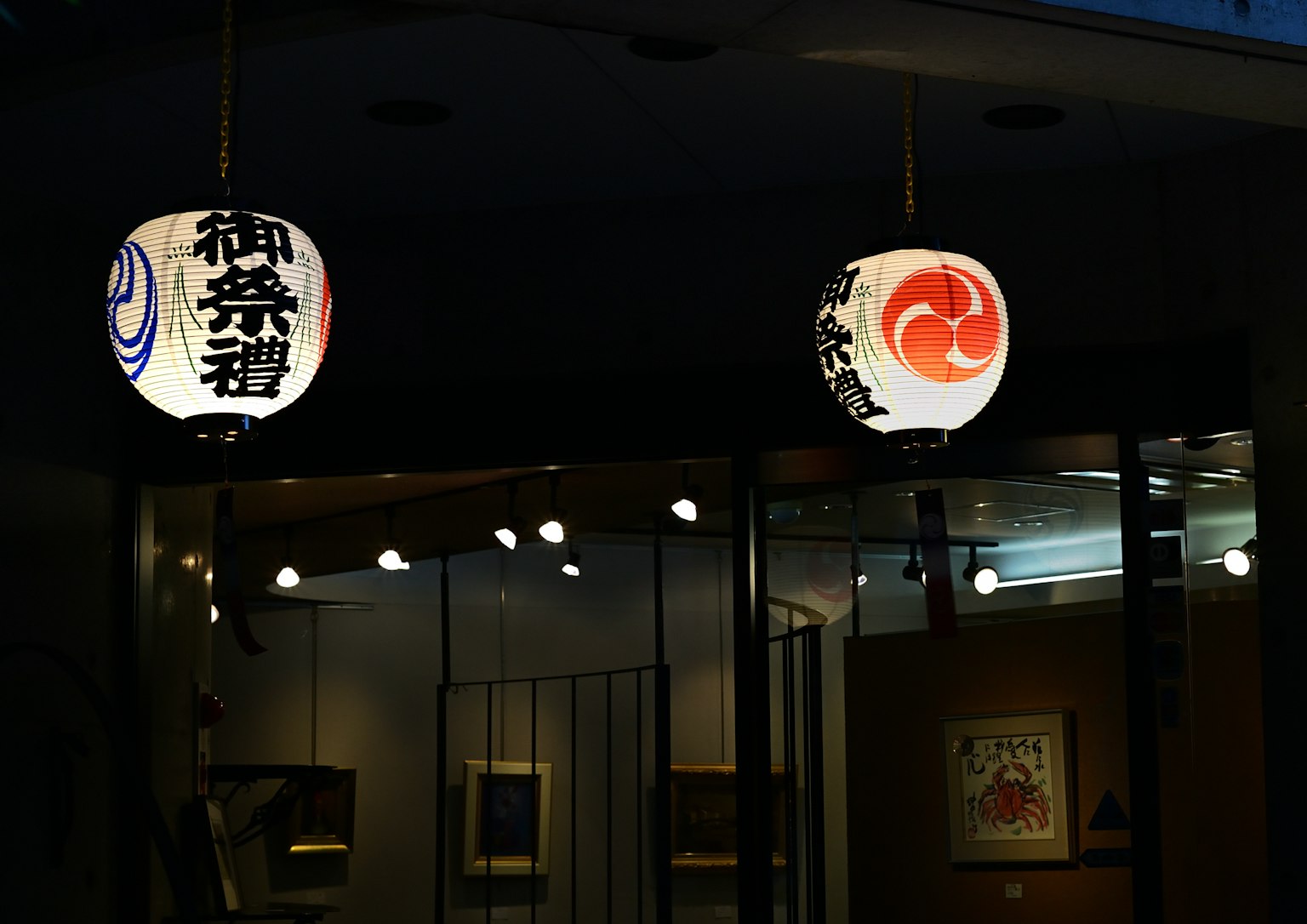 Traditional Japanese lanterns illuminated against a dark background featuring distinct designs