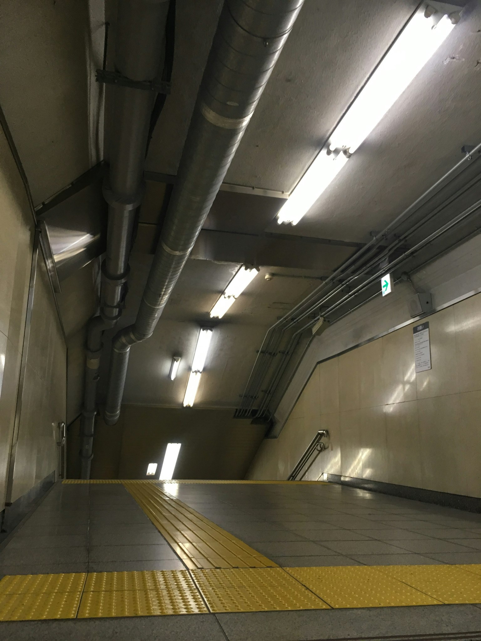 地铁走廊，荧光灯和黄色触觉铺路