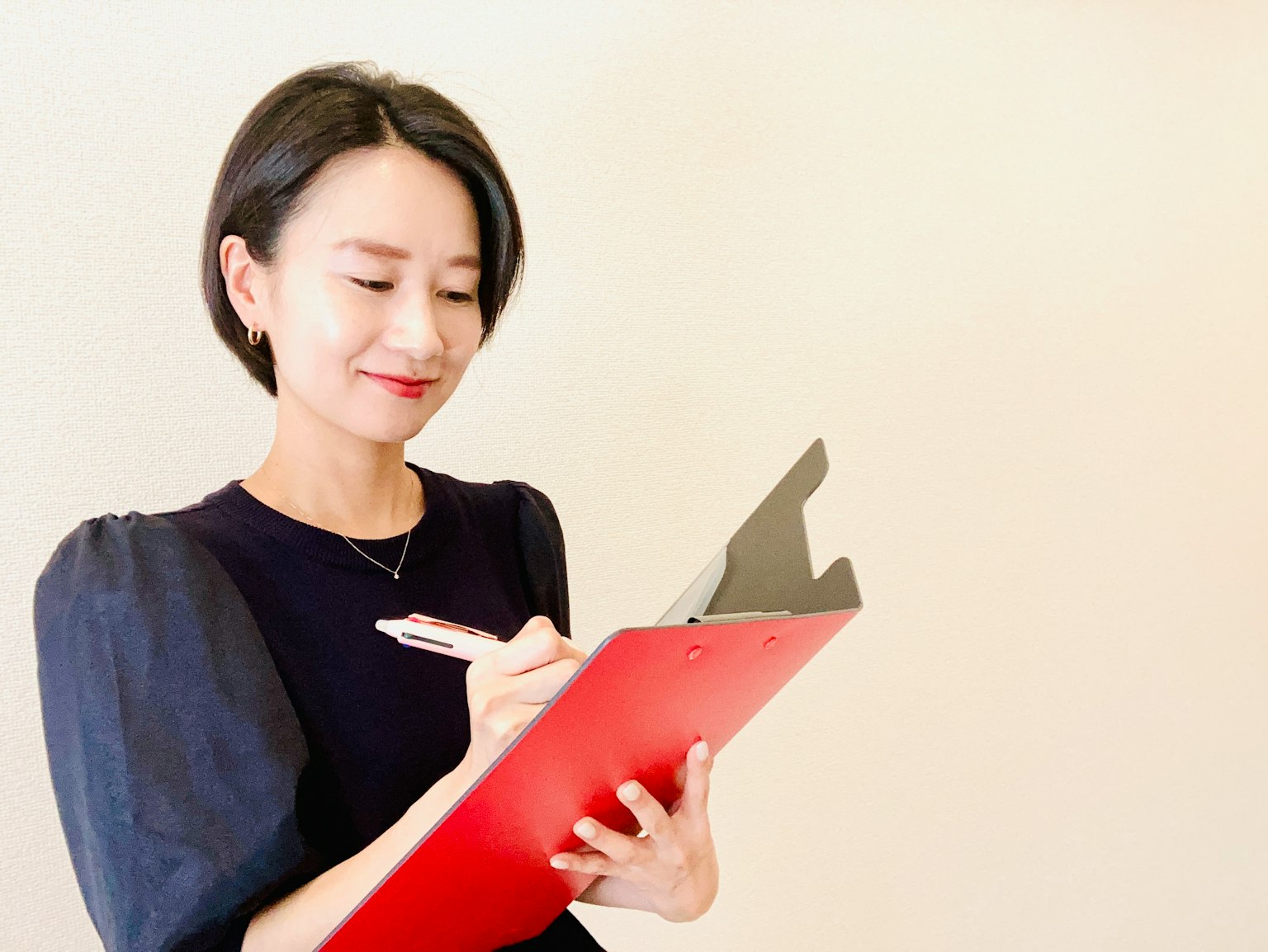 Une femme écrivant sur un clipboard rouge