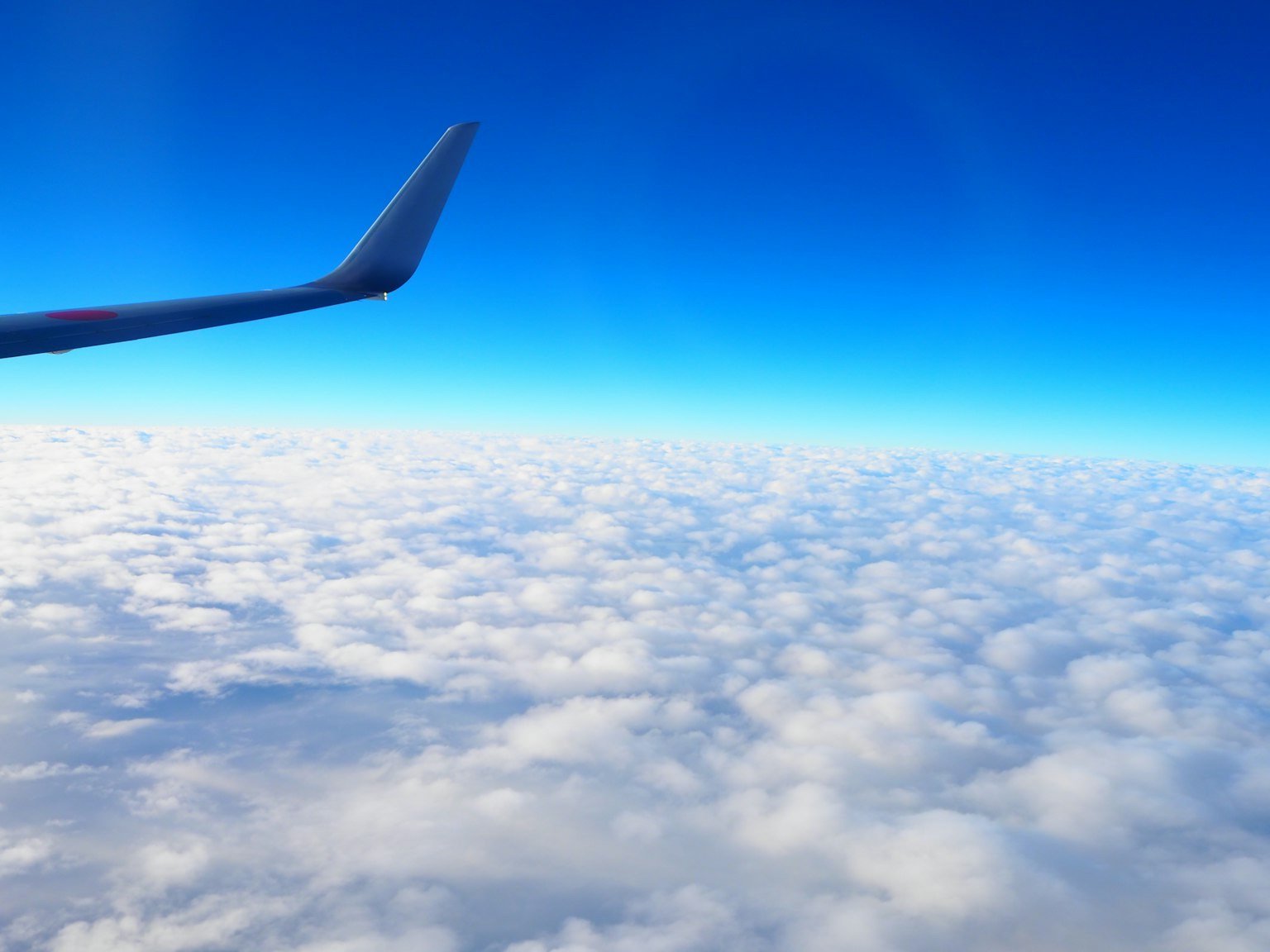 清澈藍天上的雲和飛機機翼