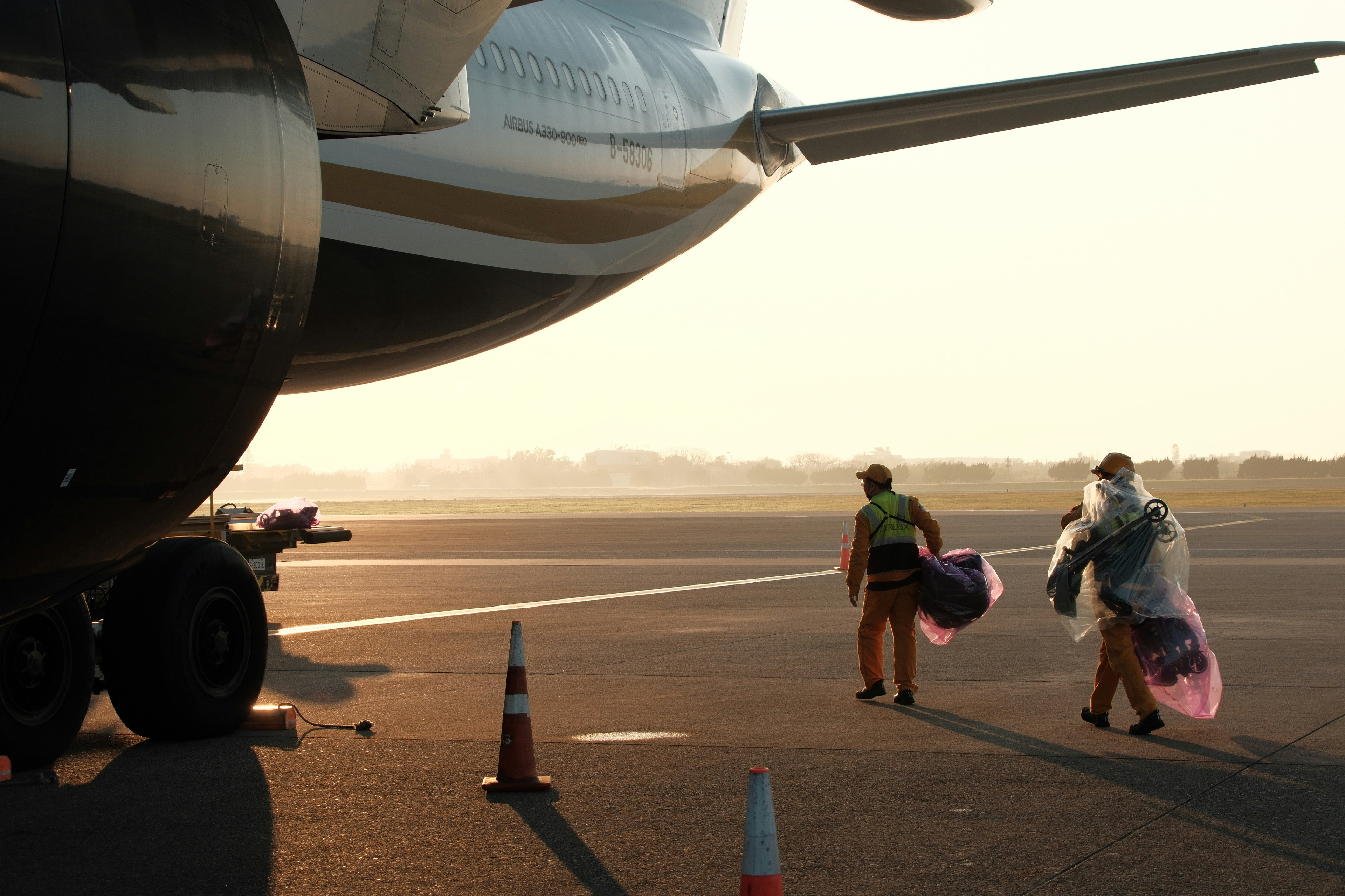 Reisende laufen auf der Startbahn neben einem Flugzeug