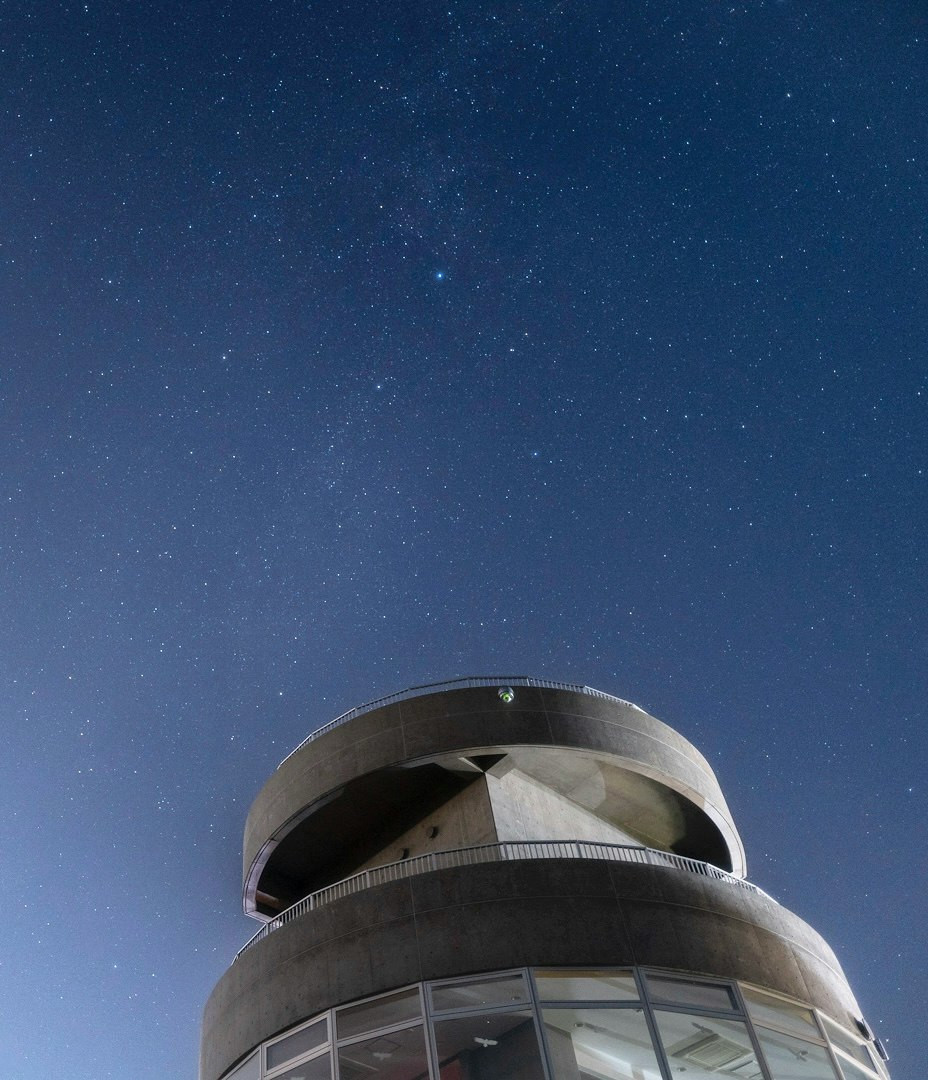 夜空の下にそびえる丸い展望塔の建物