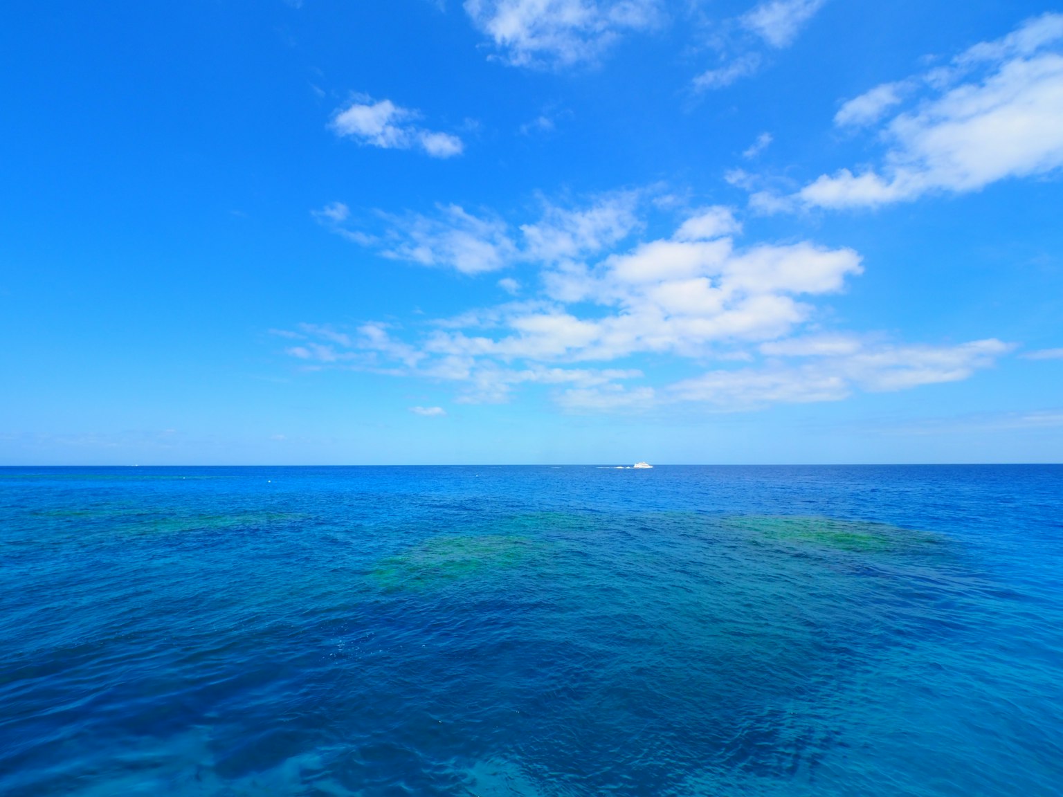Amplio océano azul y cielo con nubes dispersas